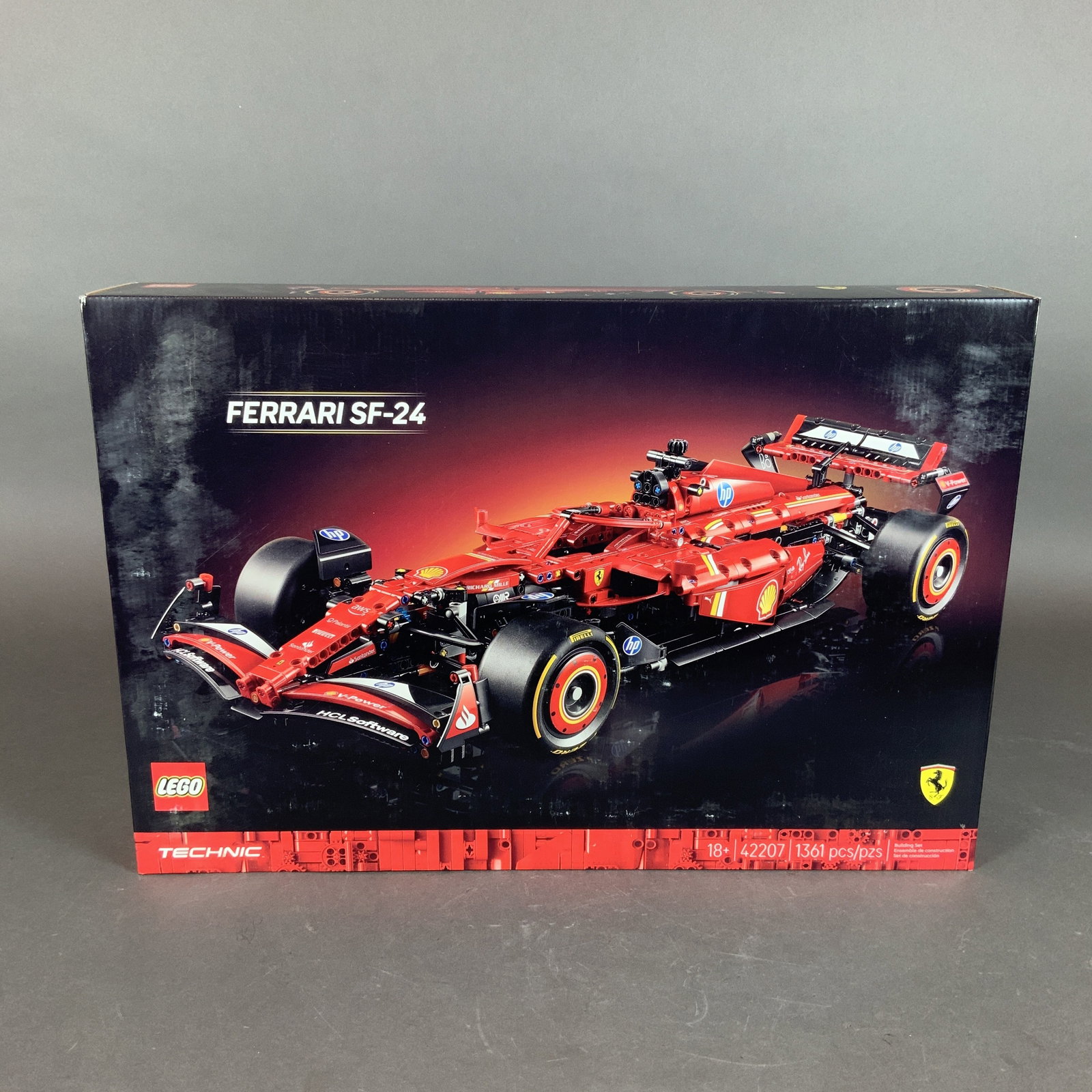LEGO Technic Ferrari SF-24 F1 Car Set 42207: A LEGO Technic construction set of the Ferrari SF-24 Formula 1 race car, set number 42207. This 1:8 scale model is composed of 1,361 plastic pieces. The model features functional mechanical elements c