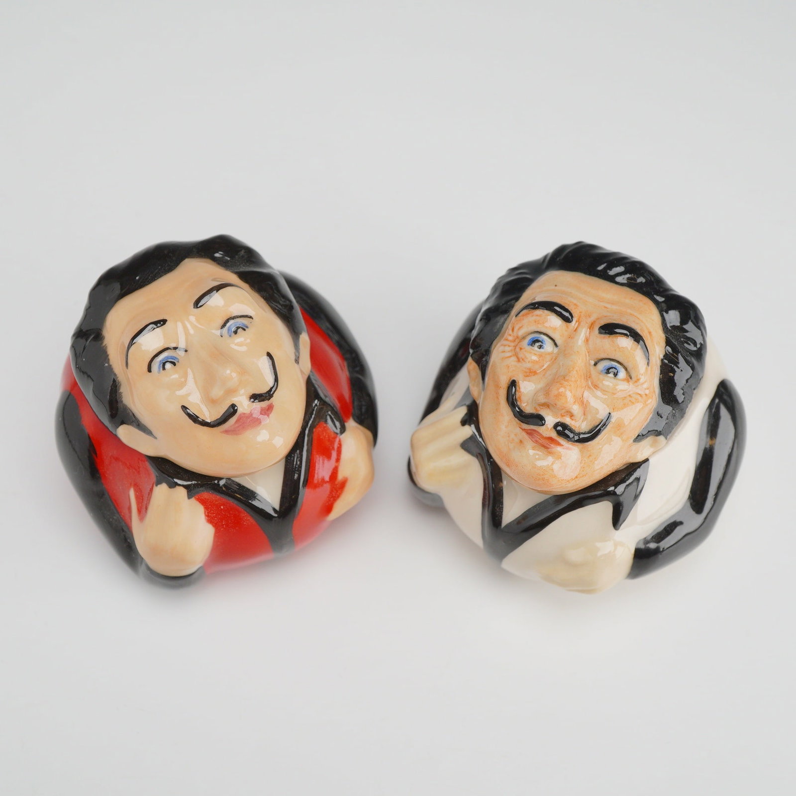 2pc Kevin Francis Face Pots, Salvador Dali: A pair of lidded glazed porcelain Face Pots produced by Kevin Francis, featuring caricatures of the artist Salvador Dali. The design captures the artist's iconic features, including his signature uptu