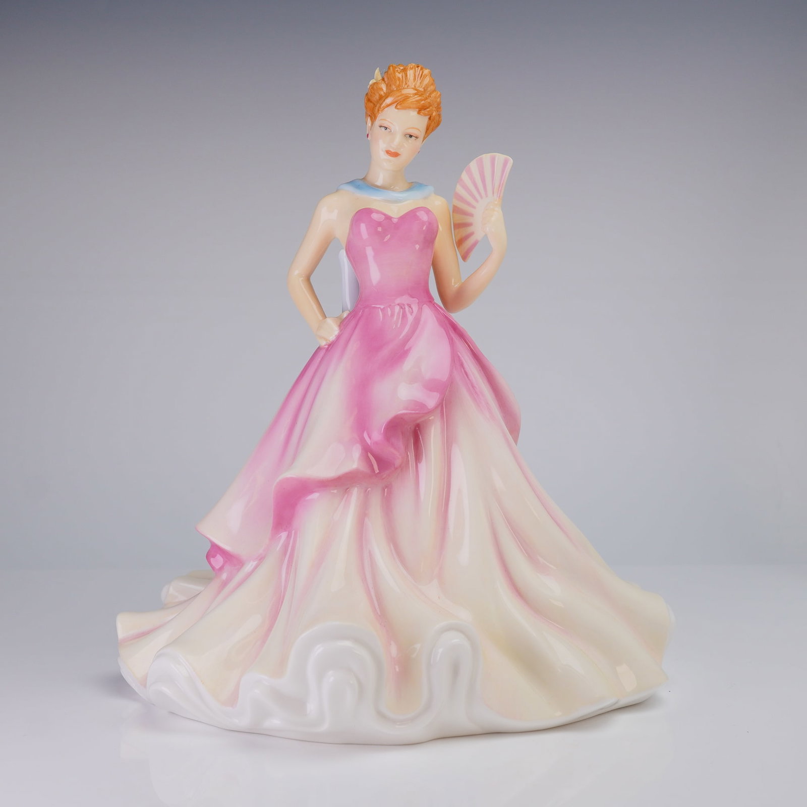 Royal Doulton Pretty Ladies Summer Ball HN 5464 Figurine: A Royal Doulton Bone China Figurine, Summer Ball (HN5464), depicting a woman in a pink and cream gown with a blue sash, bearing the maker's marks "PRETTY LADIES" and "DESIGNED IN ENGLAND" on the base.