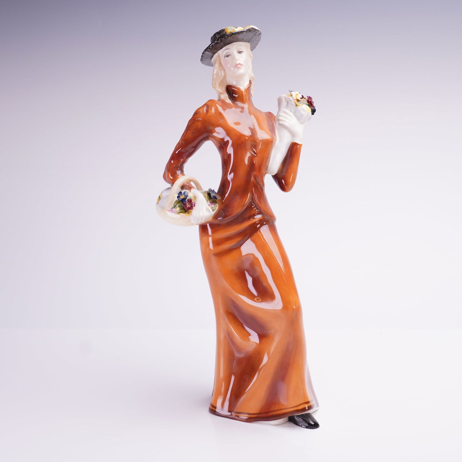 Royal Doulton Eliza HN2543 Figurine: A Royal Doulton fine bone china figurine titled Eliza, model number HN2543. The glazed figure depicts a standing lady in late Victorian or Edwardian style attire, wearing a long reddish-brown gown wit