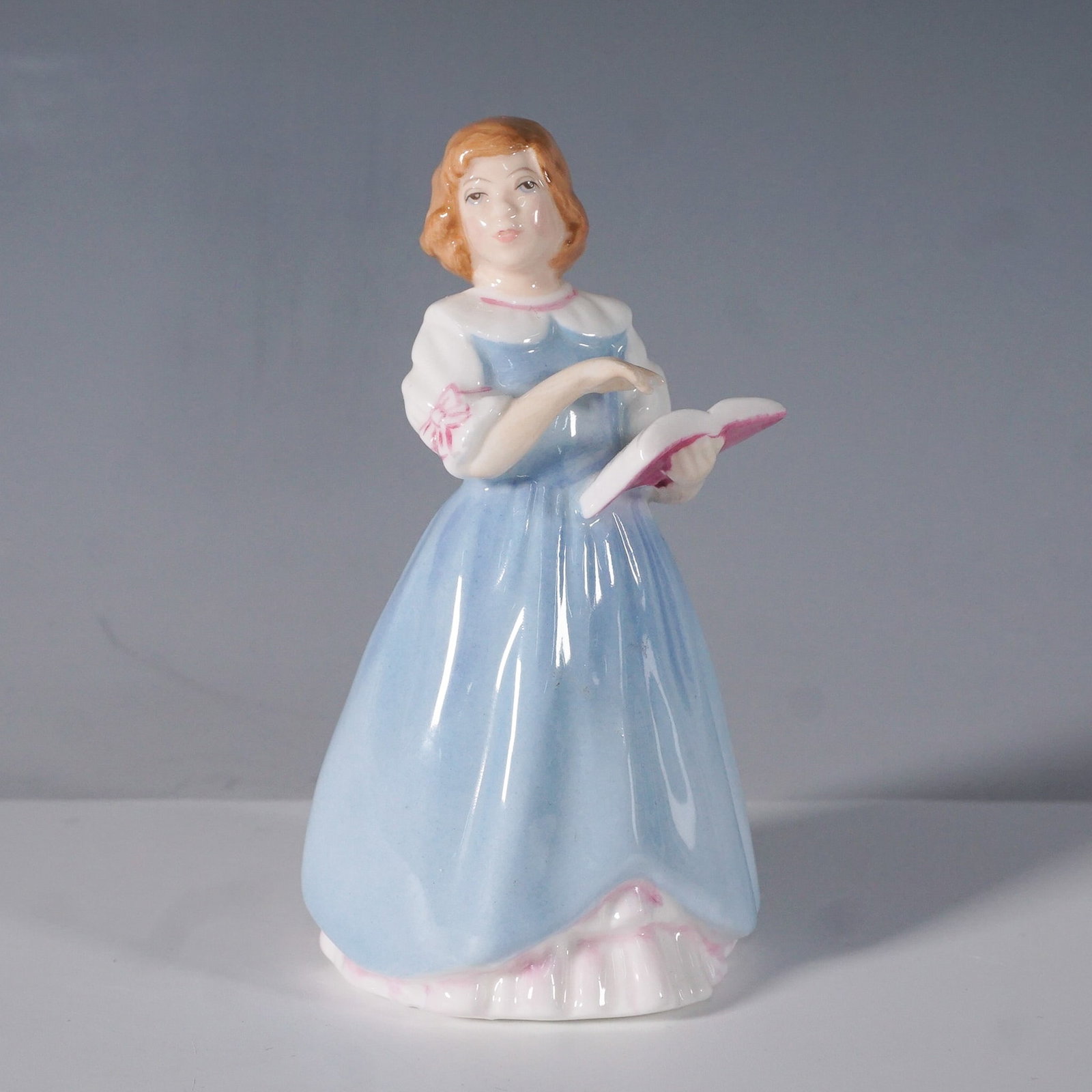 Royal Doulton First Recital Figurine HN3652: A charming Royal Doulton porcelain figurine titled First Recital, model number HN3652. Designed by Nada Pedley and issued in 1994, this beautifully hand-painted figurine captures the innocence and joy