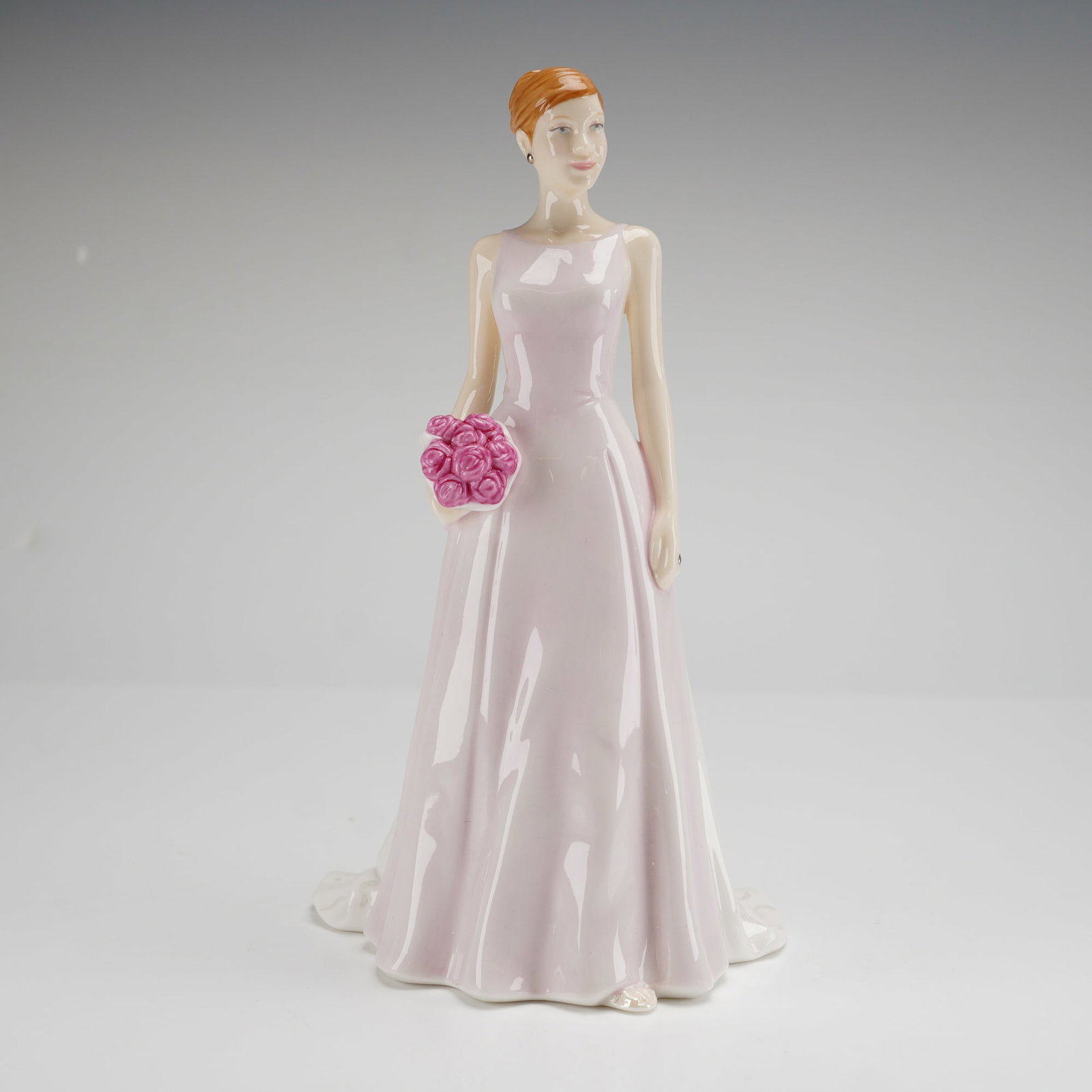 Royal Doulton Rose Bouquet HN 4796 Petite Figurine: This Royal Doulton Rose Bouquet HN 4796 petite figurine is part of the Pretty Ladies collection. Constructed of bone china, the piece depicts a woman in a pale pink sleeveless gown holding a bouquet o