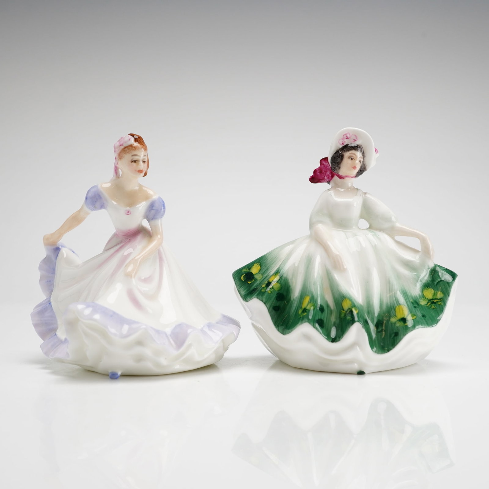 Two Royal Doulton Mini Figurines Sunday Best HN3218 & Ninette HN3215: Both pieces were designed by Peggy Davies and feature hand-decorated details on bone china. The Ninette figurine, copyright 1970, is depicted in a white gown with lavender-shaded ruffles and bodice ac