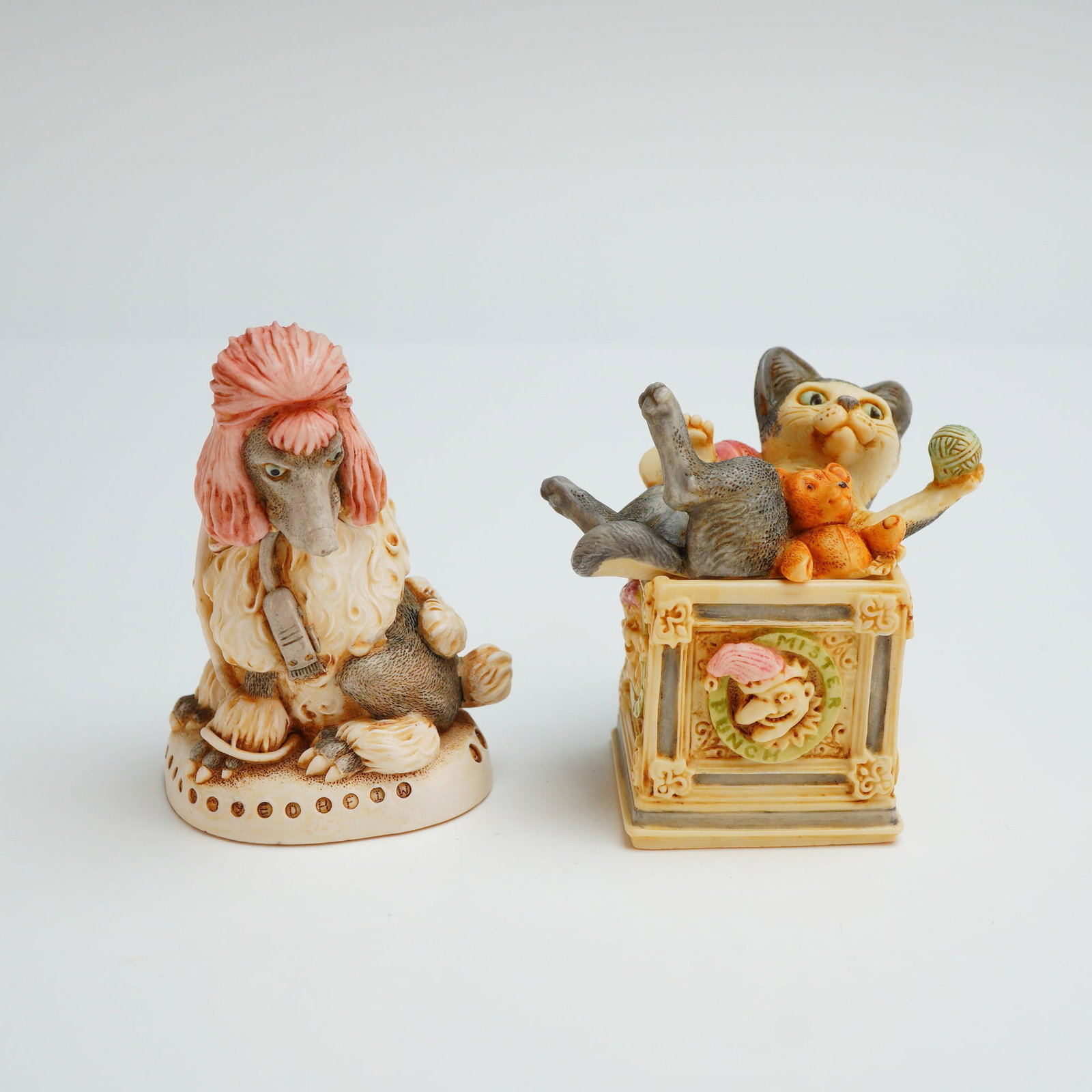 2pc Harmony Kingdom Box Figurines, Beau Brummel & Courtenay: The Beau Brummel box, bearing a copyright, is shaped as a stylized poodle with a pink crest and gray fur, featuring a removable head that opens to a hollow interior containing a small hidden carving.