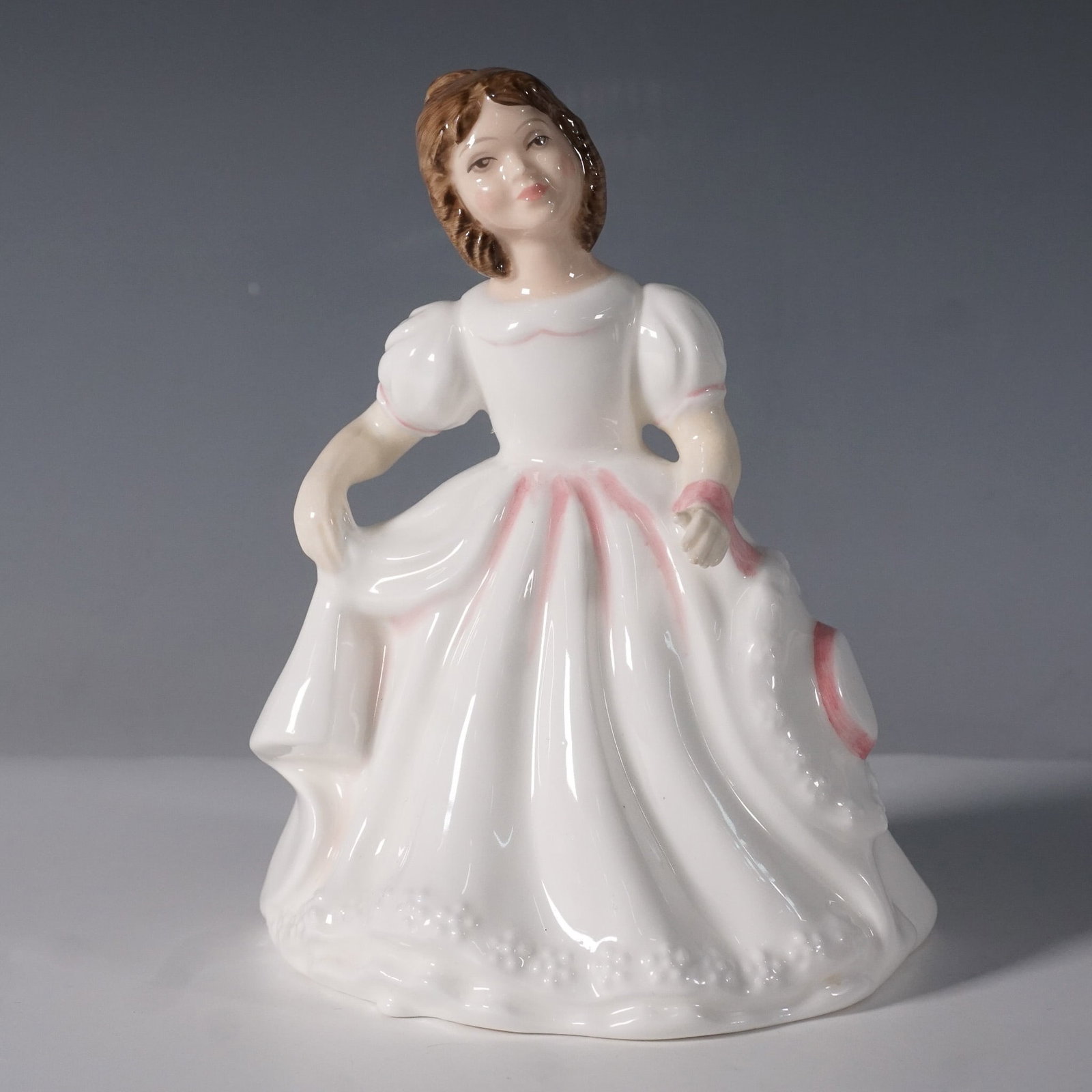 Royal Doulton Amanda Figurine HN3406: Royal Doulton Amanda HN3406, a hand-decorated bone china figurine designed by Robert Tabbenor. Originally issued in 1985, this figurine is presented in the new colorway from 1993. It features a young 