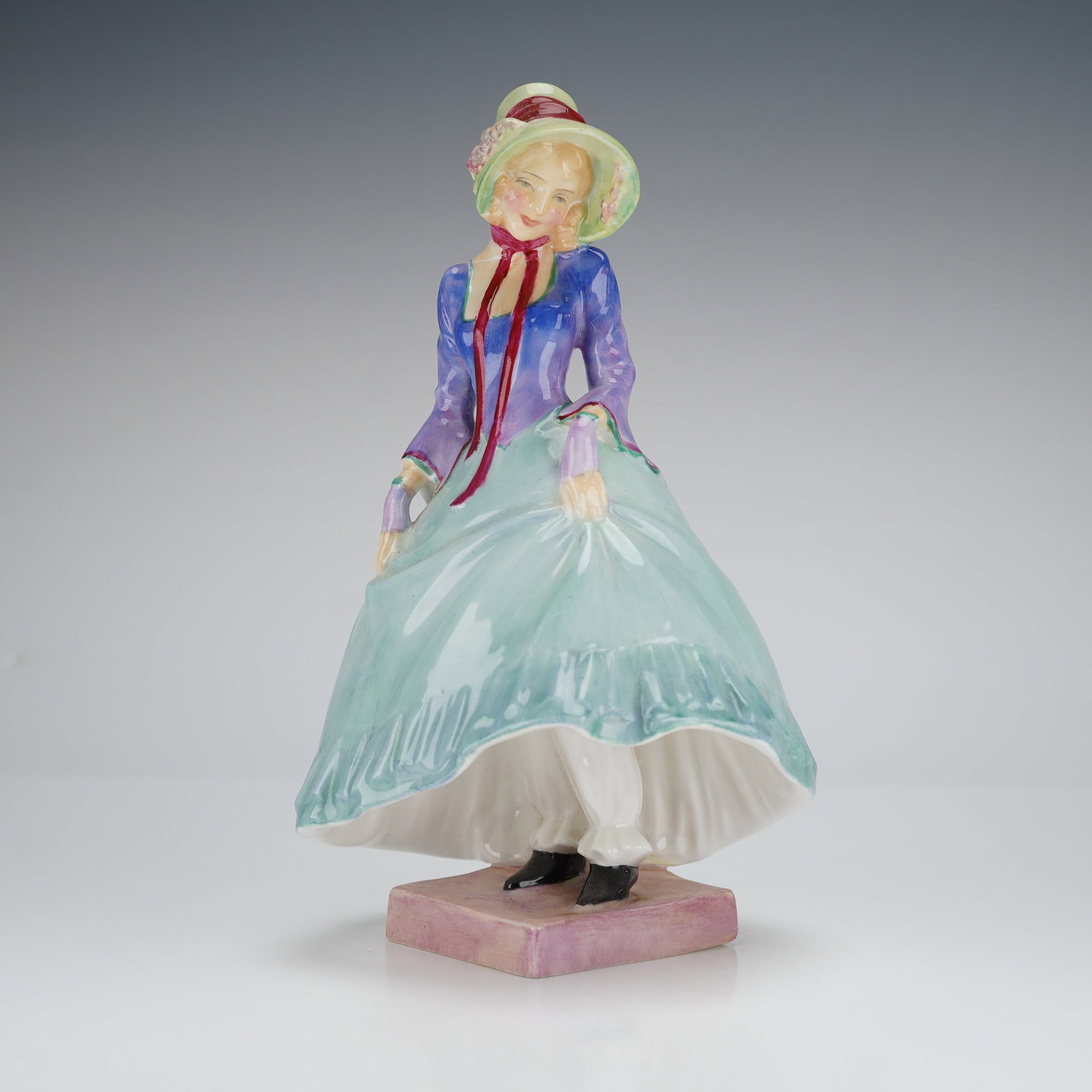 Royal Doulton Figurine Pantalettes HN1362: A single glazed bone china figurine titled "Pantalettes," model number HN1362, manufactured by Royal Doulton, England. The figurine depicts a young woman standing in period dress, characterized by a w