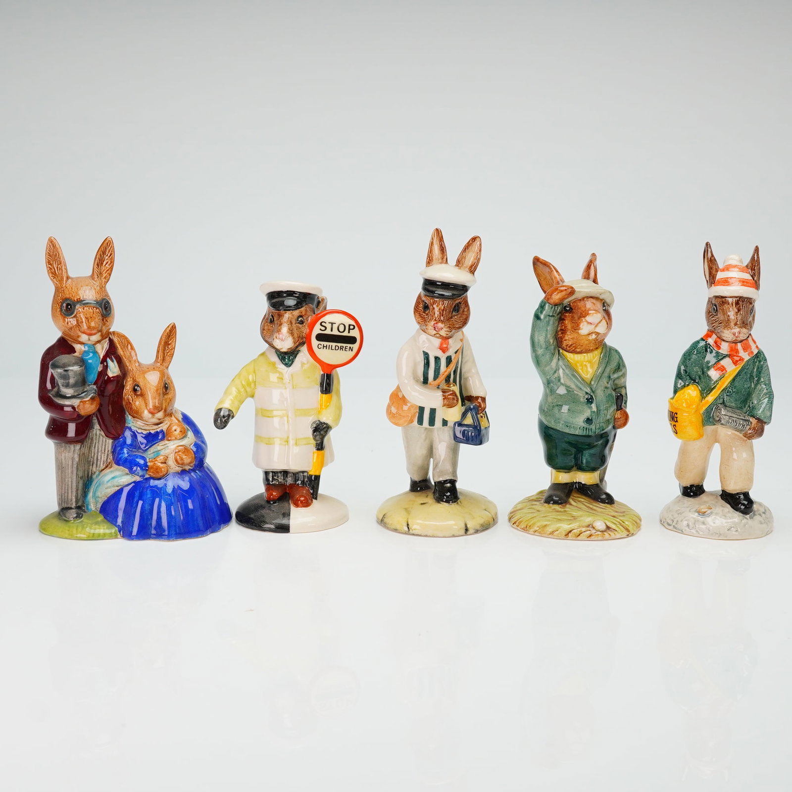 5pc Royal Doulton Bunnykins Figurines, DB1, 32, 65, 77 & 125: A collection of five Royal Doulton Bunnykins figurines crafted from hand-painted glazed ceramic. This group includes the models Paperboy DB77, Lollipopman DB65, Bogey DB32, Milkman DB125, and Family P