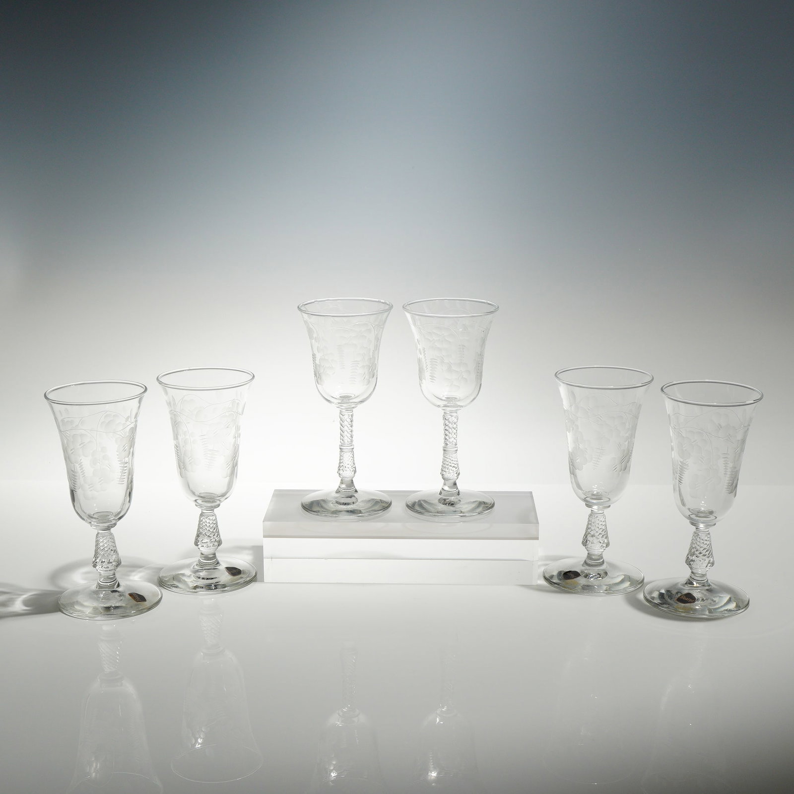 6pc Rock Sharpe Crystal Floral Etched Wine and Juice Glasses: This collection of four juice glasses and two wine glasses features clear, hand-blown bowls decorated with a wheel-etched floral and leaf motif, showcasing a stylized central flower surrounded by fern