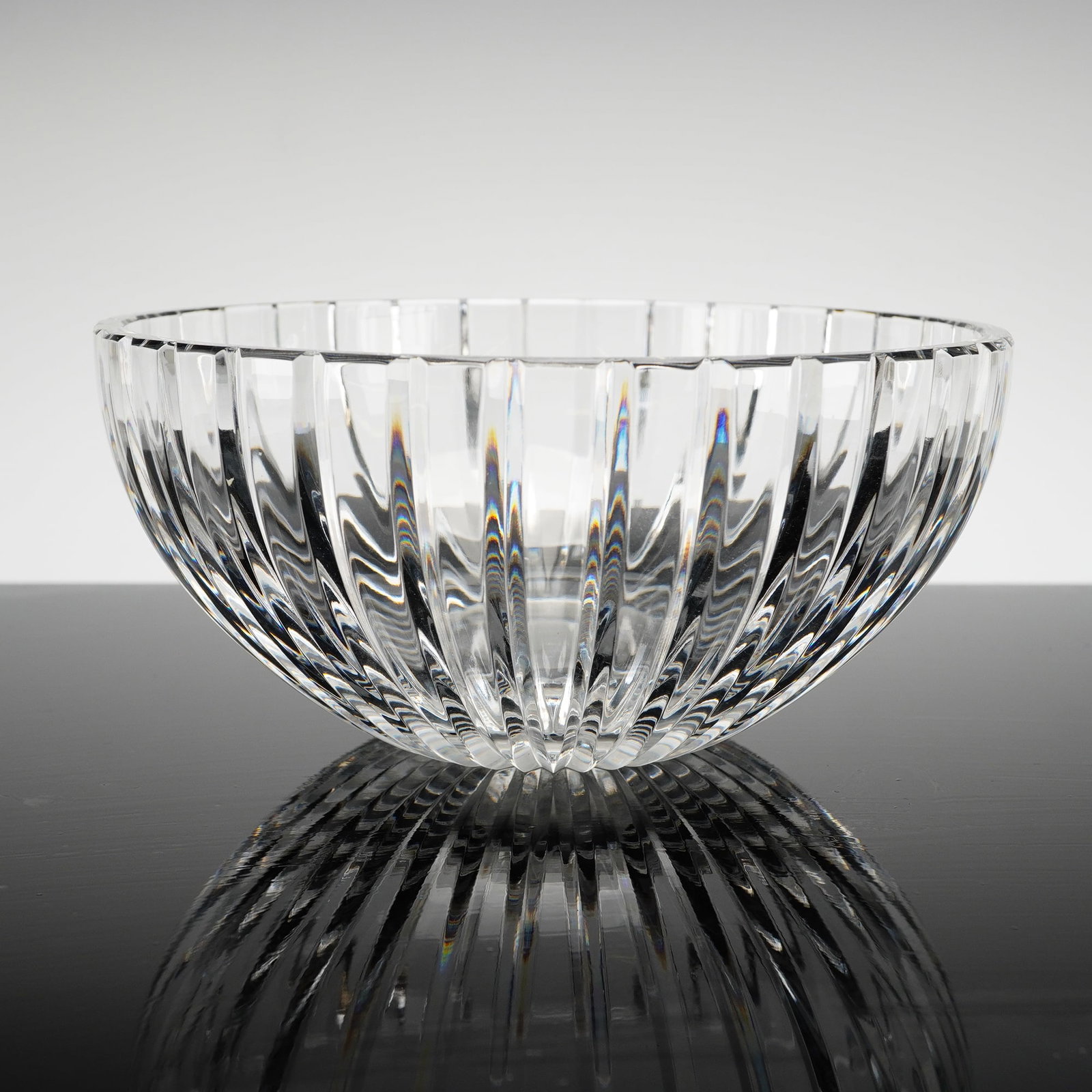 Marquis by Waterford Palladia Crystal Bowl: This Marquis by Waterford crystal bowl designed in the Palladia pattern is constructed from clear crystalline and features a modern hemispherical form. The exterior decoration consists of deep, vertic