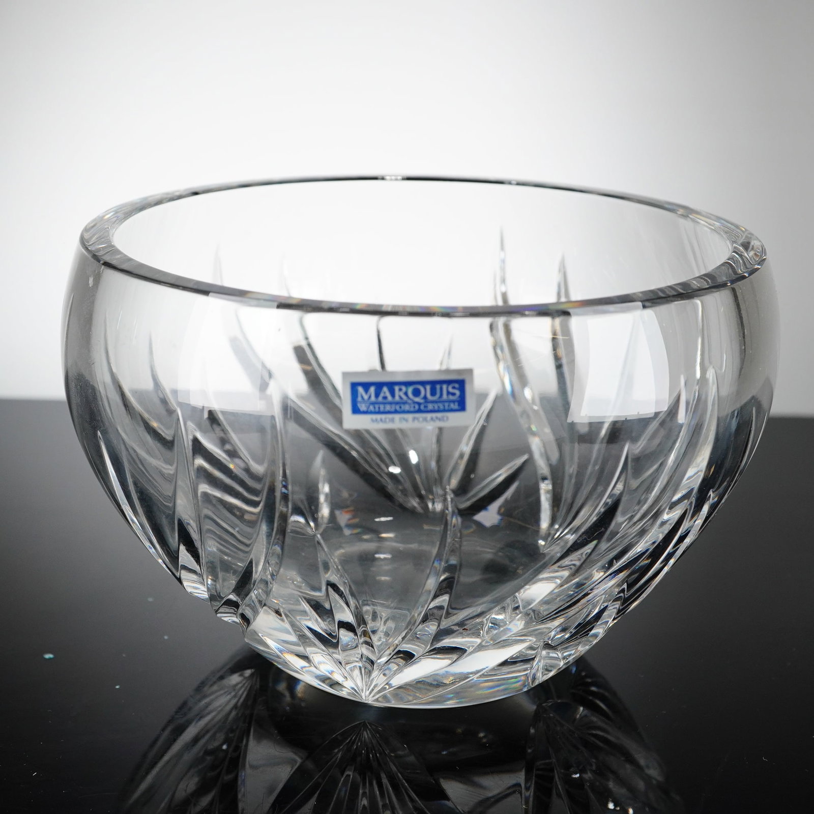 Marquis by Waterford Wyndmere Cut Crystal Bowl: A Marquis by Waterford crystal bowl in the Wyndmere pattern, manufactured in Poland. The clear crystalline vessel is designed in a rounded rose-bowl form, decorated with deep, sweeping vertical wedge 