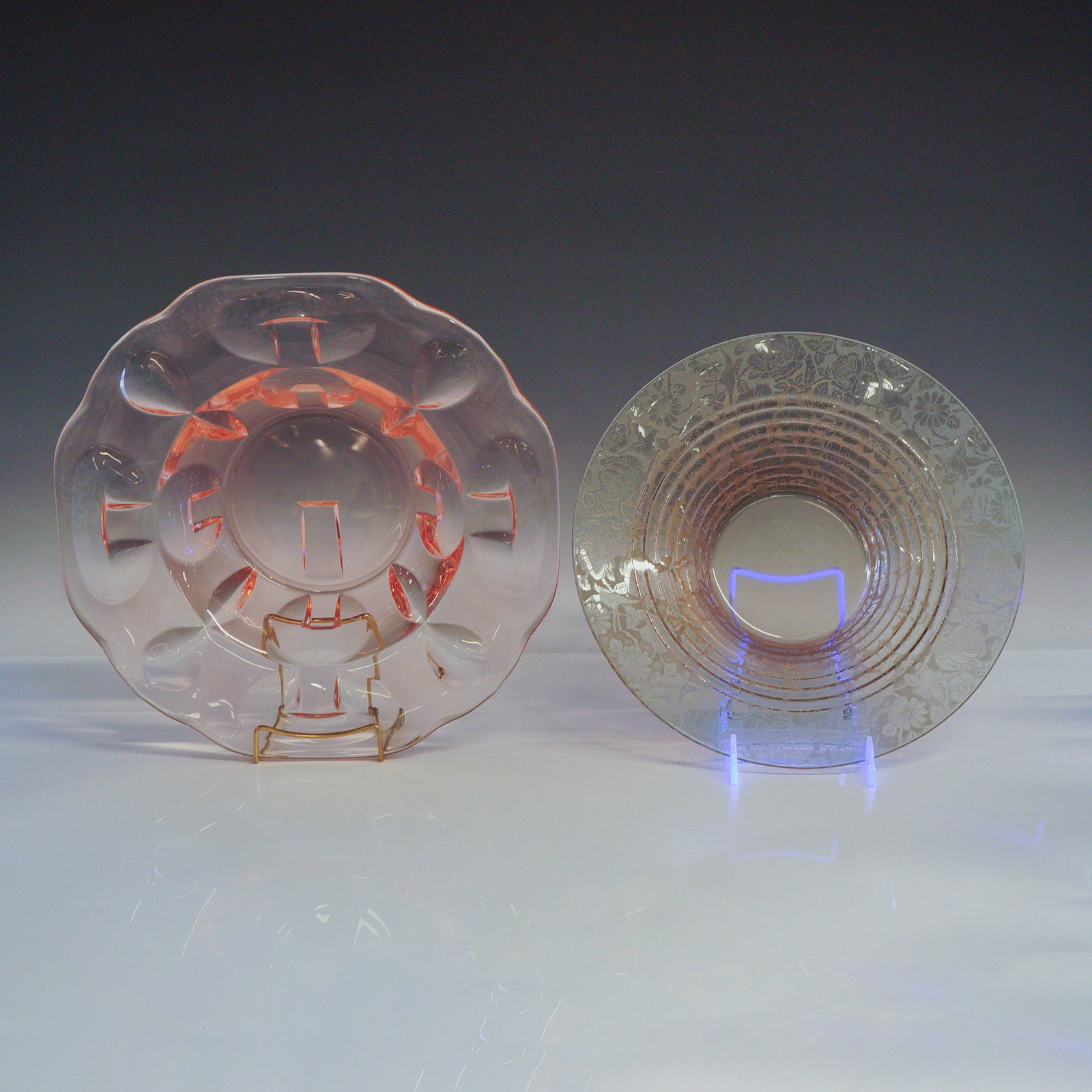 2pc Pink Art Glass Floral Bowls: This lot consists of two pink glass bowls produced in the United States. The first piece is a shallow bowl with the body made to look like a flower with its lobed shape and relief work, featuring a sc