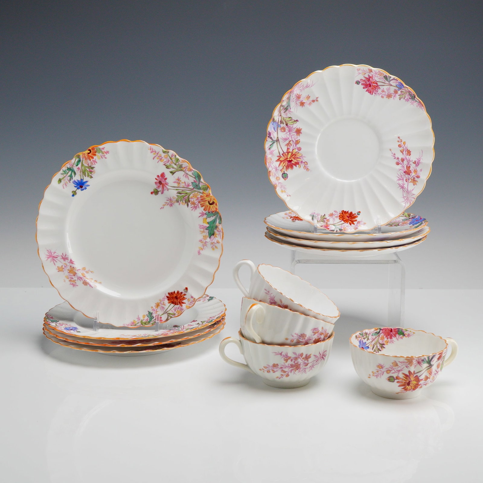 Spode Copeland 12pc Cups, Saucers and Dessert Plates, Chelsea Garden: A twelve-piece partial tea service for four in the Chelsea Garden pattern by Spode Copeland. The service is manufactured from fine bone china in England. The decoration consists of colorful floral spr