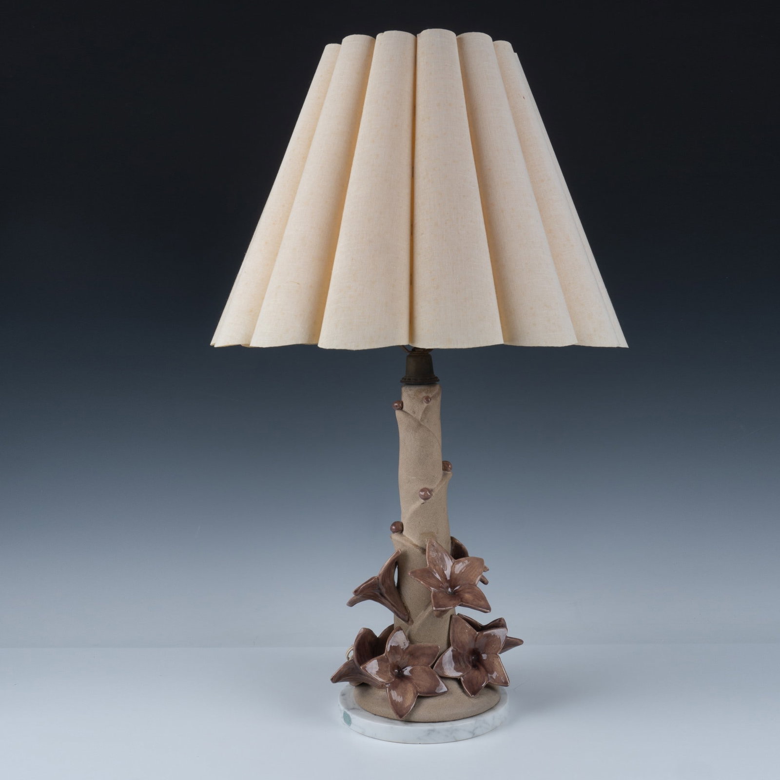Ceramic Floral Lamp: A stylized beige trumpet vine lamp with trumpet flowers in a deep dark pink rose color glaze on a round white marble base. Dimensions: 8"dia x 27"H Date or Era: 20th century