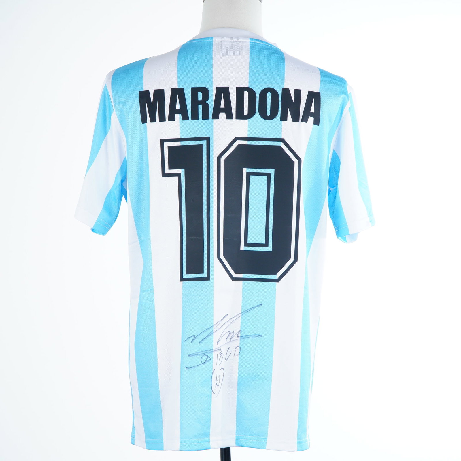 Diego Maradona Signed Argentina National Team 1986 Replica Jersey with The Dugout COA: This lot features a Maradona Signed Argentina Jersey, a replica of the iconic 1986 home shirt worn during the legendary World Cup victory in Mexico. The jersey is crafted in the classic light blue and