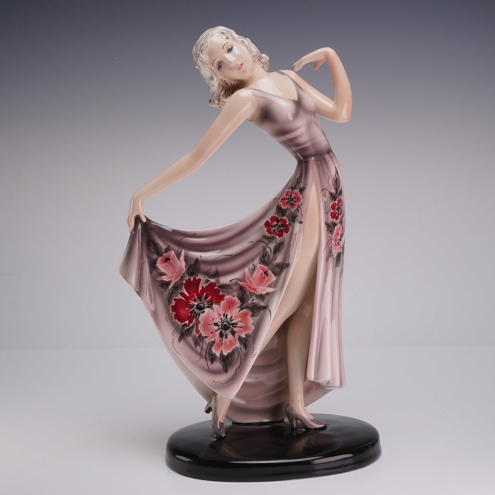 Stefan Dakon for Goldscheider Vienna Porcelain Figurine, Dancer 7958: This Goldscheider porcelain figurine is an Art Deco period work designed by Stefan Dakon in Vienna, Austria. The glazed ceramic figure depicts a dancing woman in a rhythmic pose, holding the hem of a 