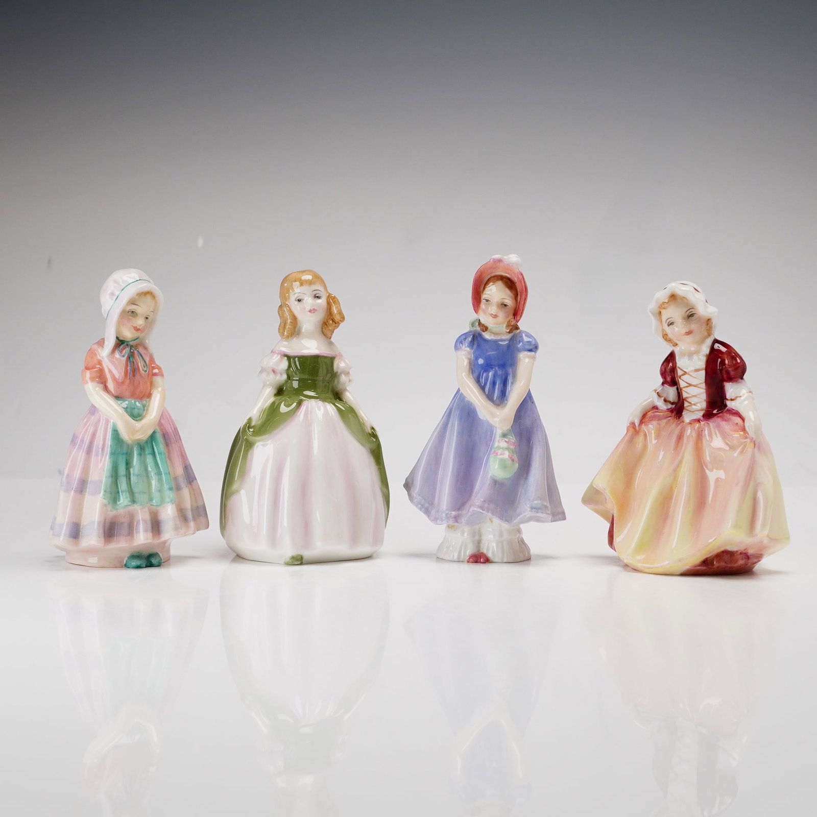 Collection of Four Royal Doulton Figurines, Tootles, Penny, Ivy, and Dinky Do: This collection consists of four Royal Doulton figurines featuring young girls in traditional attire. The group includes the Tootles model, depicted in a pink and purple horizontally striped skirt wit