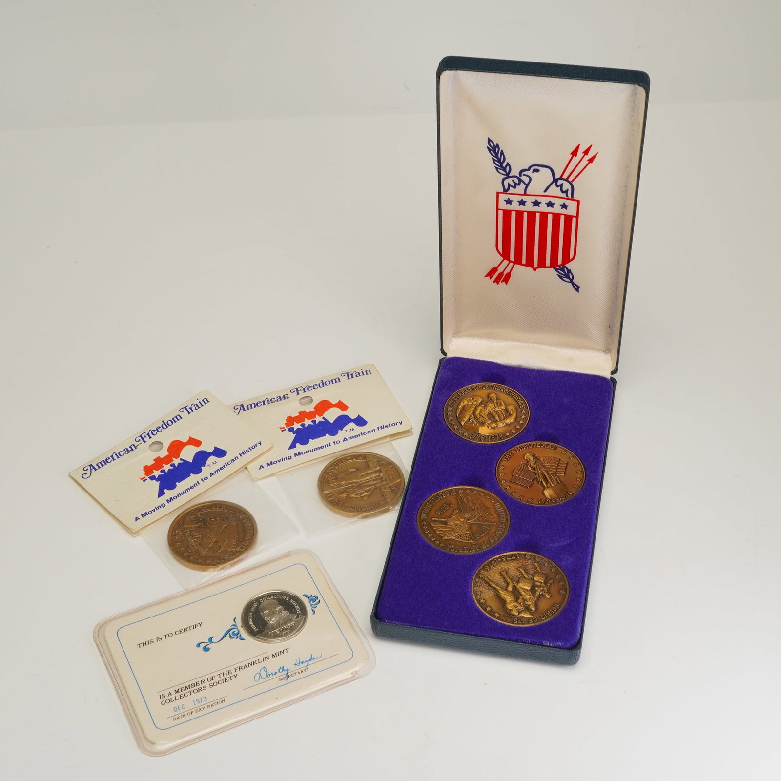 7pc US Bicentennial Medallion Grouping including Freedom Train and Franklin Mint: A 7pc American medallion grouping produced by the Franklin Mint to commemorate the US Bicentennial. The collection includes four large bronze-composition medals housed in a blue velvet-lined presentat