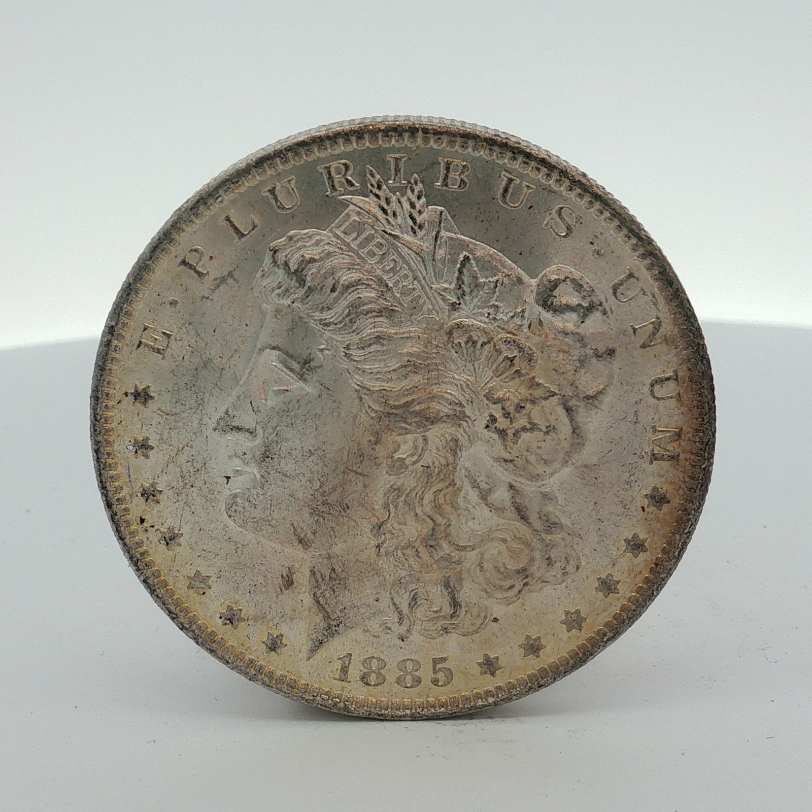 1885-O US Morgan Silver Dollar Coin Circulated: This US Morgan silver dollar was struck at the New Orleans Mint in 1885. The coin is composed of 90% silver and 10% copper with a reeded edge. It features the Morgan dollar obverse and heraldic eagle 