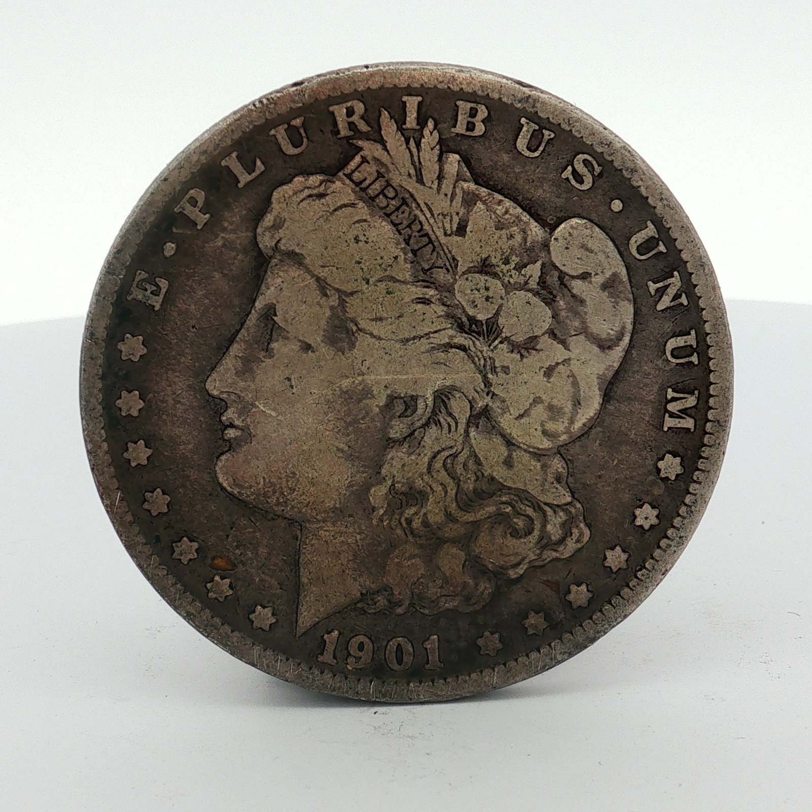 1901-O US Morgan Silver Dollar: This US Morgan silver dollar was struck at the New Orleans Mint in 1901. The coin is composed of 90% silver and 10% copper. It features the Morgan design. An O mint mark is located on the reverse belo