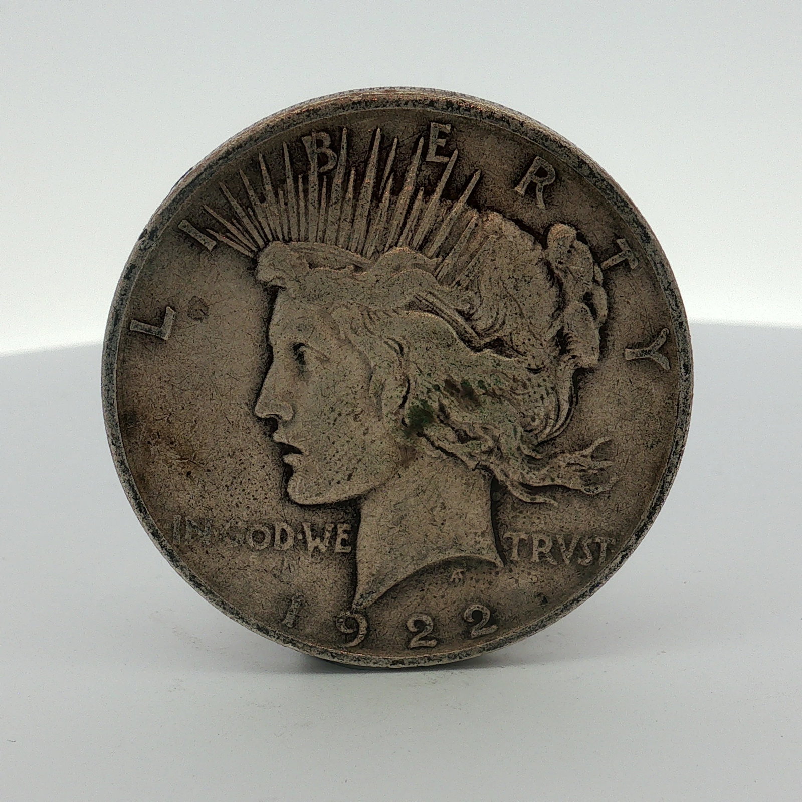 1922-D US One Dollar Silver Peace Dollar, Circulated: 1922 US silver Peace dollar, Denver mint. This coin features the Liberty obverse and Eagle reverse. Inscriptions include LIBERTY, IN GOD WE TRVST, and the date 1922 on the obverse, with UNITED STATES 