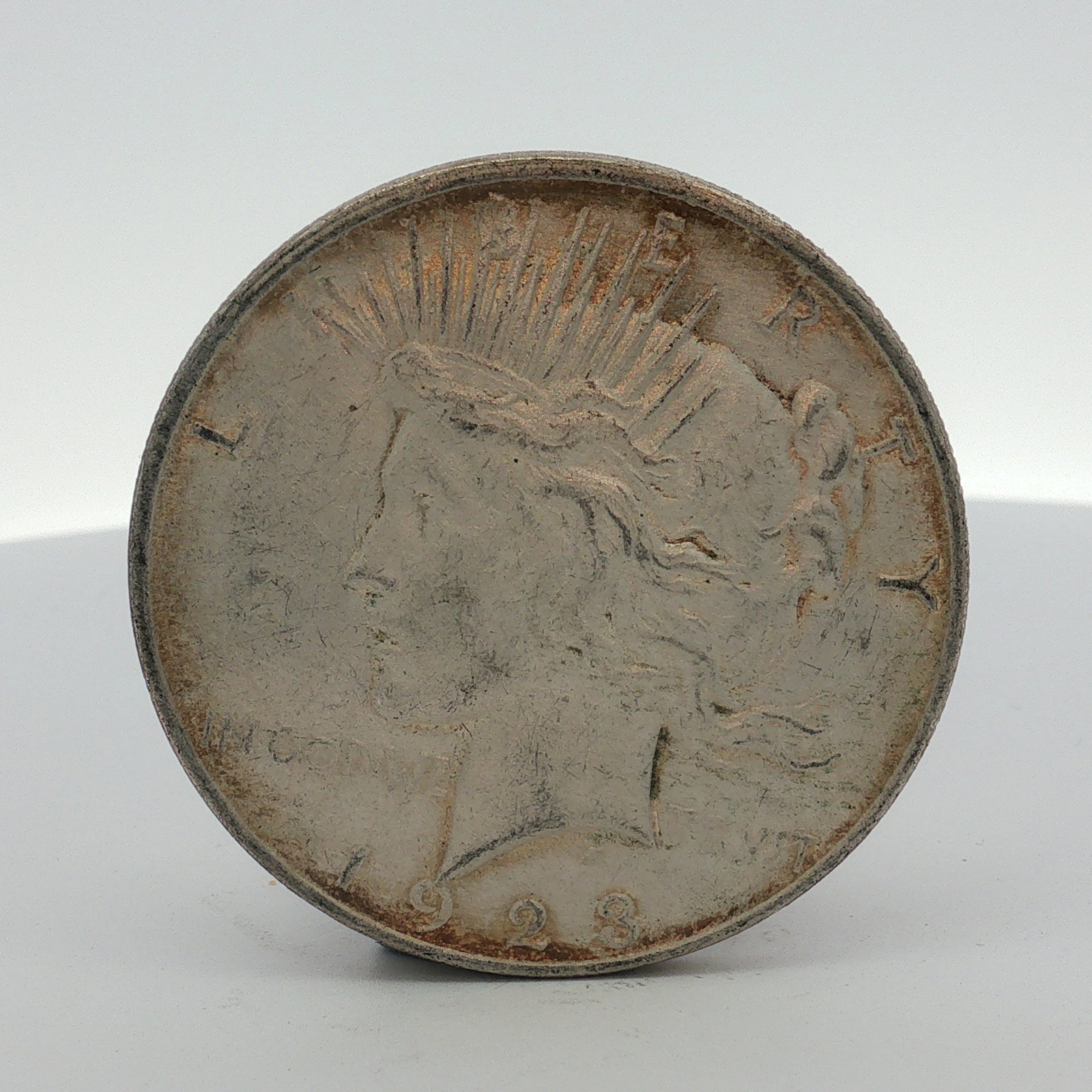 1923-D US One Dollar Peace Silver Dollar, Circulated: Peace dollar, US 1923-D this coin is composed of 90% silver and 10% copper. The obverse features the Peace dollar design with the date 1923 and the inscriptions LIBERTY and IN GOD WE TRVST. The revers