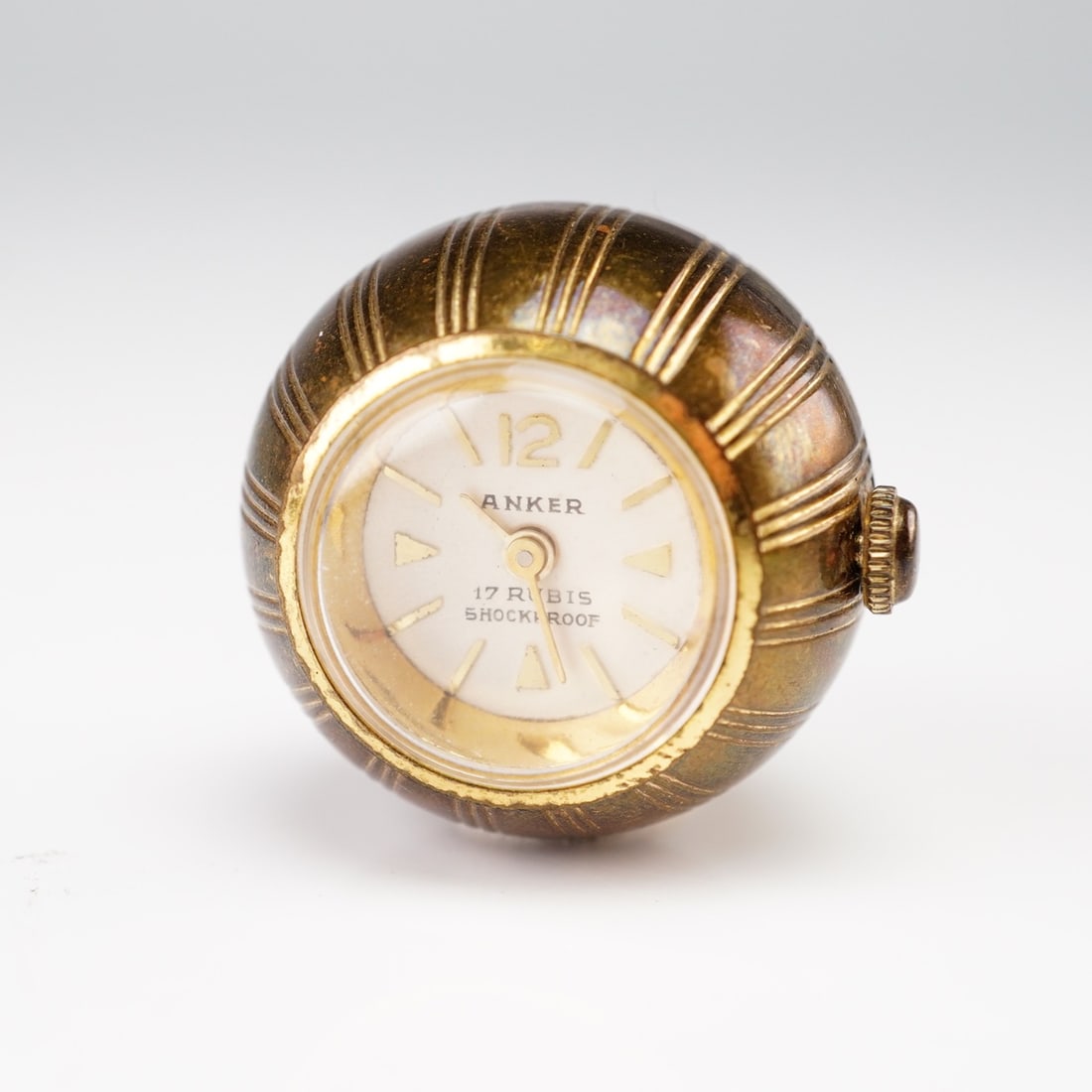 Anker 17 Rubis Gold-Tone Metal Ball Pendant Watch: Brand: Anker. Model: Spherical Ball Pendant Watch. Reference: N/A. Movement: Manual wind, 17 Rubis. Case: Gold-tone metal with vertically ribbed finish. Dial: Off-white with gold-toned Arabic 12 and a