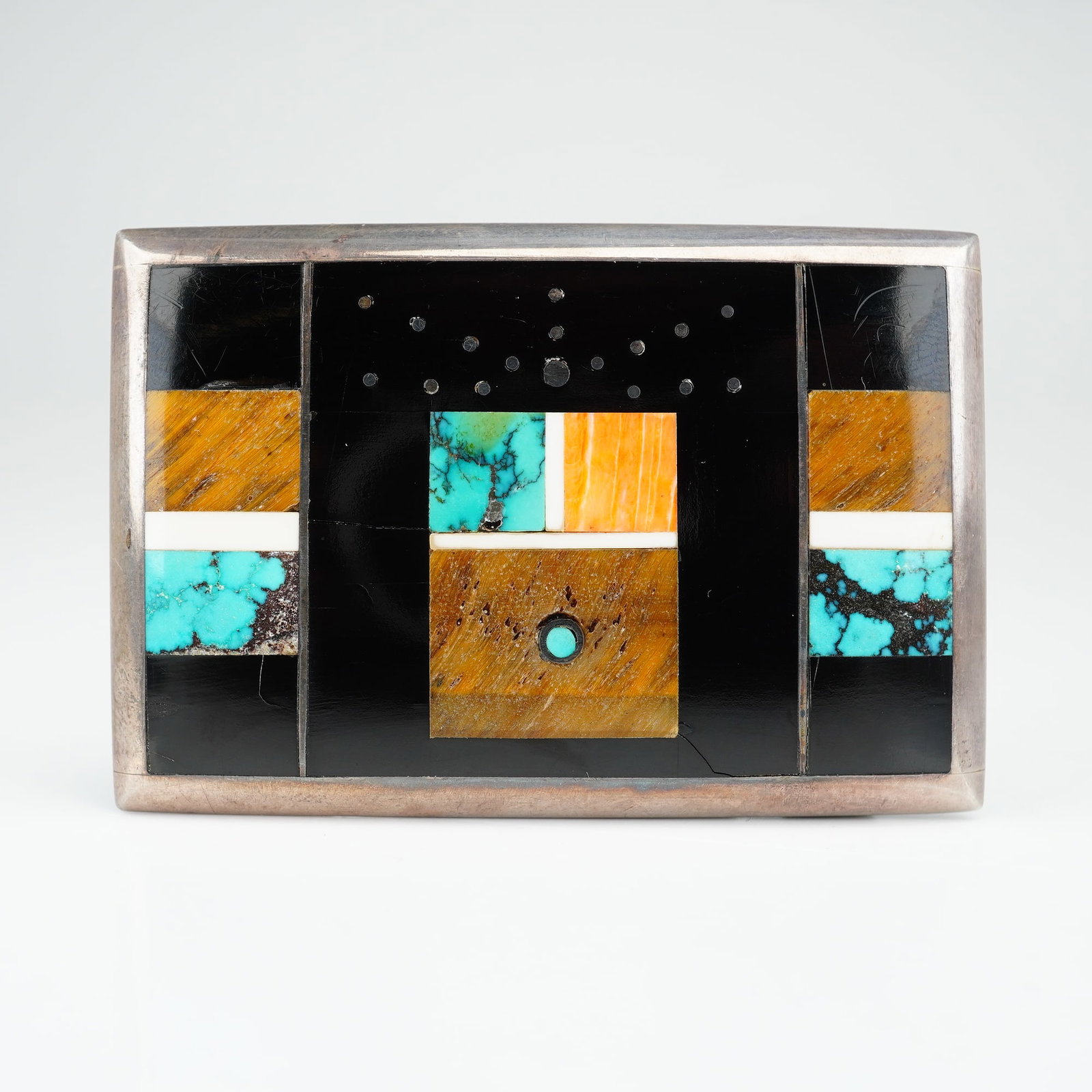 Jimmy Poyer Sterling Silver Multi-Stone Inlay Zuni Belt Buckle: This contemporary Zuni style belt buckle is crafted from sterling silver and features an intricate multi-stone micro-mosaic inlay. The rectangular buckle displays a geometric motif. The composition is