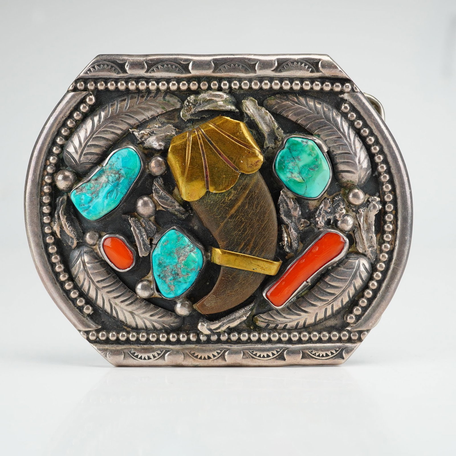 Navajo Sterling Silver Turquoise and Coral Bear Claw Belt Buckle Signed Moore: This Navajo sterling silver belt buckle features a central bear claw centerpiece with a gold-tone metal cap and band. The design is accented by three inset turquoise nuggets with visible matrix and tw