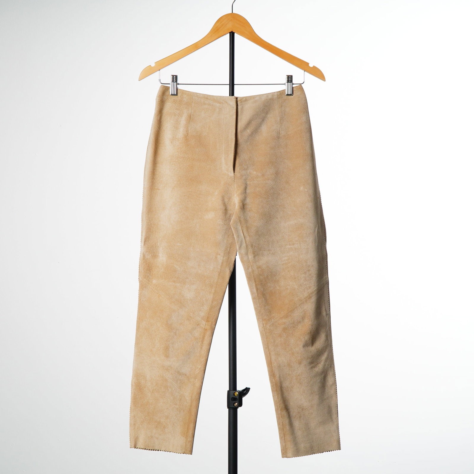 Revue Women's Tan Suede Leather High-Waisted Pants: A pair of high-waisted trousers by Revue. The garment is constructed from tan suede leather in a straight-leg silhouette. The design features a minimalist clean-front without pockets and includes dart