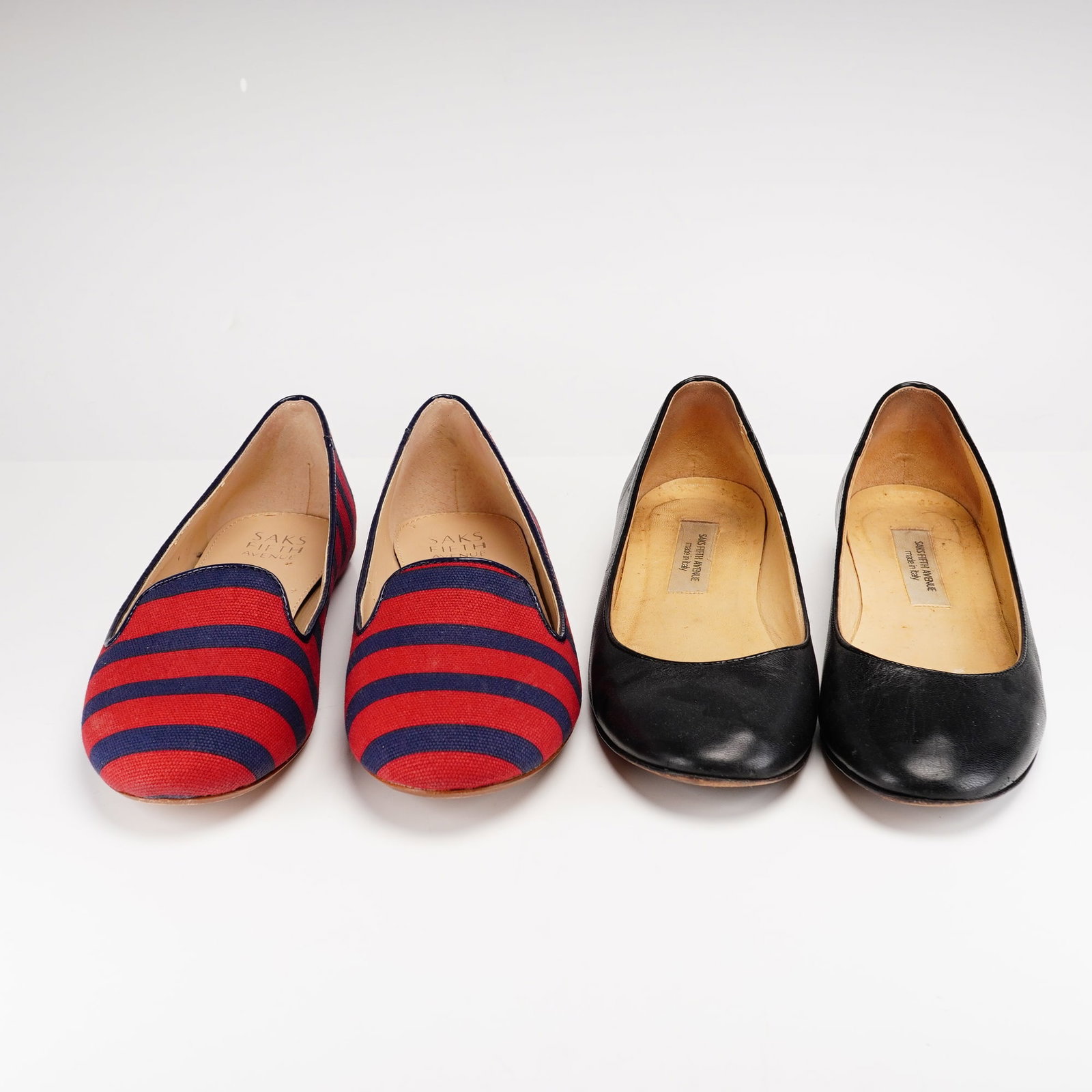 Two Pairs of Saks Fifth Avenue Loafers: Collection of two pairs of Saks Fifth Avenue slip-on loafers. One pair is crafted in red textile with navy horizontal stripes, featuring a rounded toe and low-profile silhouette; underside marked "SAK
