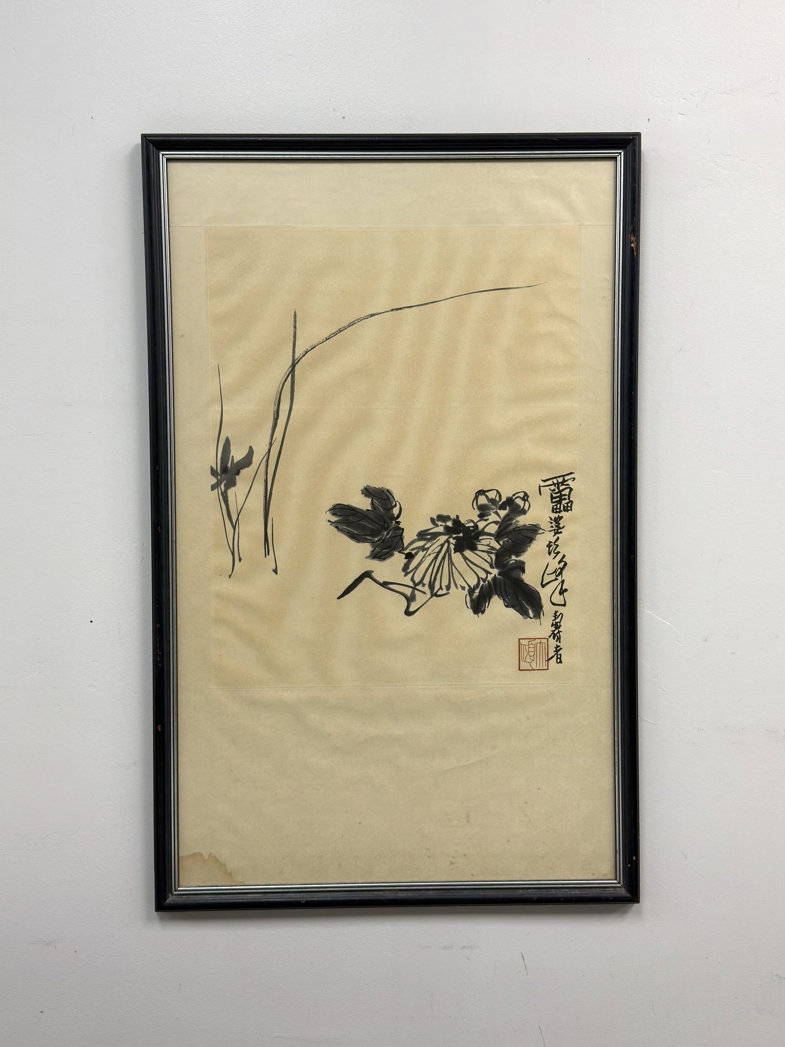 Chinese Ink Wash Painting of Chrysanthemum Attributed to Pan Tianshou: This 20th-century framed Chinese ink wash painting is attributed to the artist Xu Linlu (1897-1971). The work depicts a chrysanthemum blossom with dark, expressive leaves and slender blades of grass i