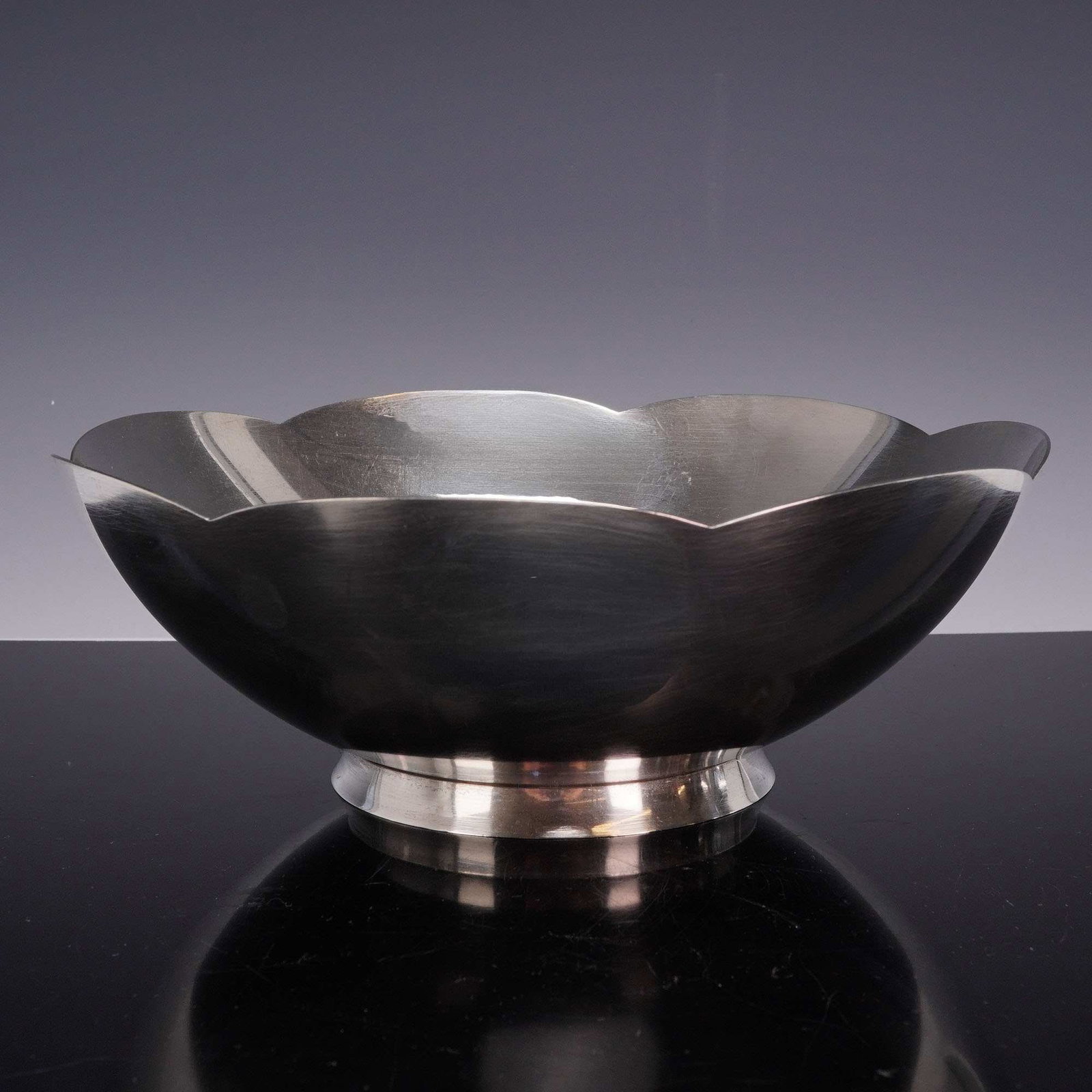 Tiffany & Co Sterling Silver Scalloped Rim Bowl: A mid-20th-century sterling silver centerpiece bowl by Tiffany & Co. This elegant piece features a minimalist, mid-century modern aesthetic with a six-lobed scalloped rim in an abstract floriform desi