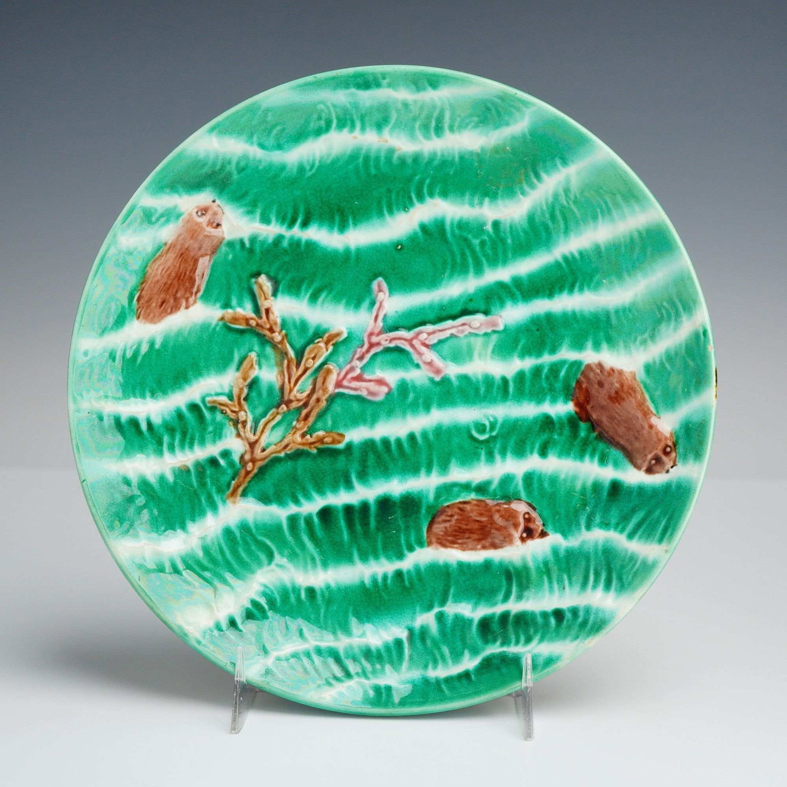 Wedgwood Majolica Ocean Pattern Plate with Swimming Seals: A circular earthenware majolica plate manufactured by Josiah Wedgwood and Sons in the Ocean pattern. The design features high-relief molded decorations of three brown seals and a multi-toned coral bra
