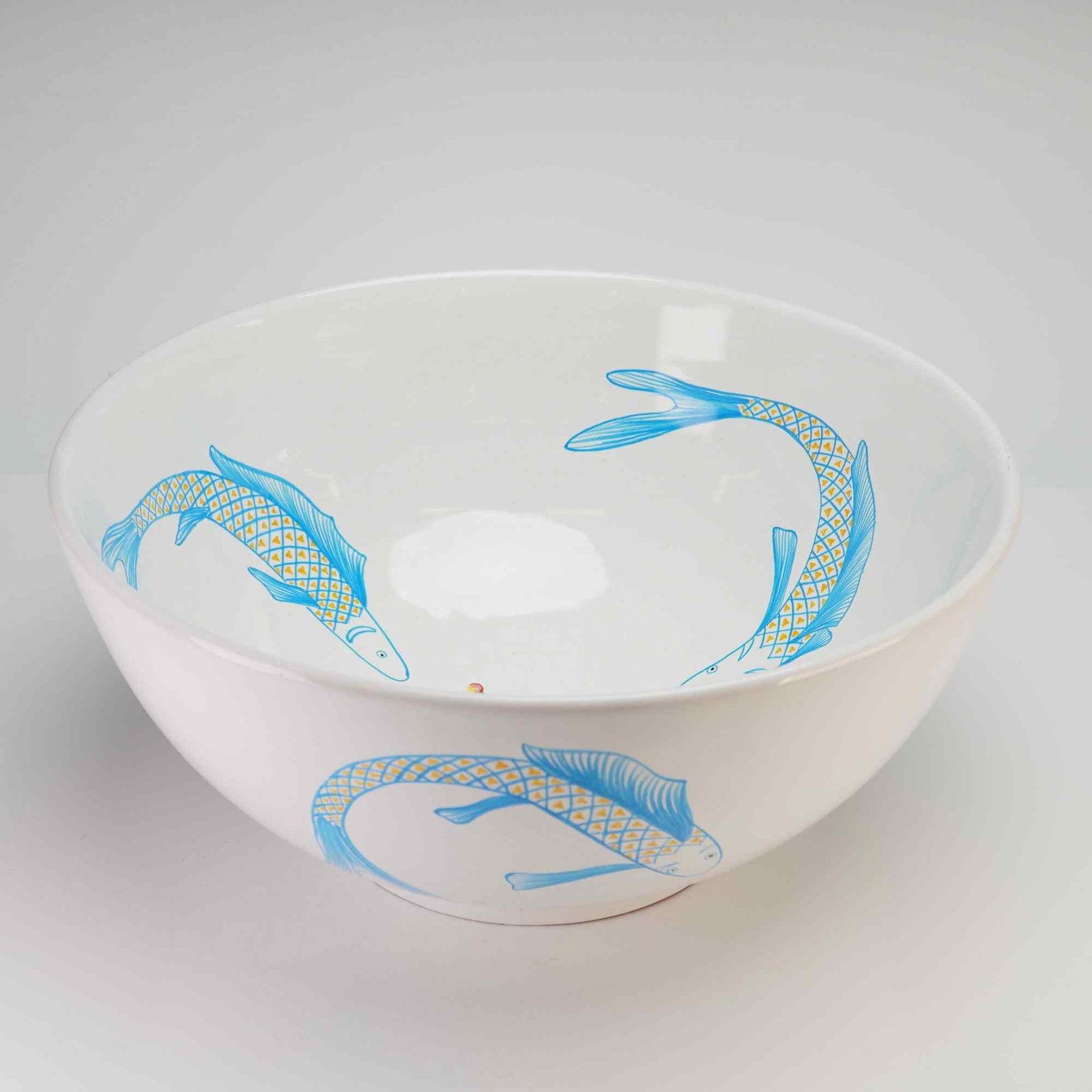 Grazia-Deruta by Maria Christina Hamel Majolica Fish Centerpiece Bowl: Italian majolica bowl designed by Maria Christina Hamel (M.C. Hamel) and produced by the Grazia factory in Deruta, Italy, for Neiman Marcus. The interior is decorated with three stylized fish in blue 