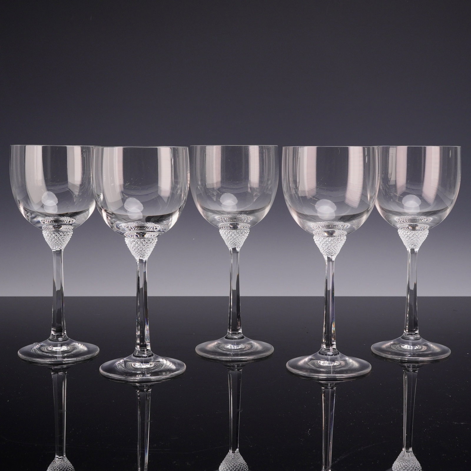 Set of Five Villeroy & Boch Octavie Crystal Claret Wine Glasses: This set of five stemware glasses is from the Octavie collection by Villeroy & Boch. Each glass is composed of clear crystal and features a rounded, tulip-shaped bowl. The base of the bowl is decorate
