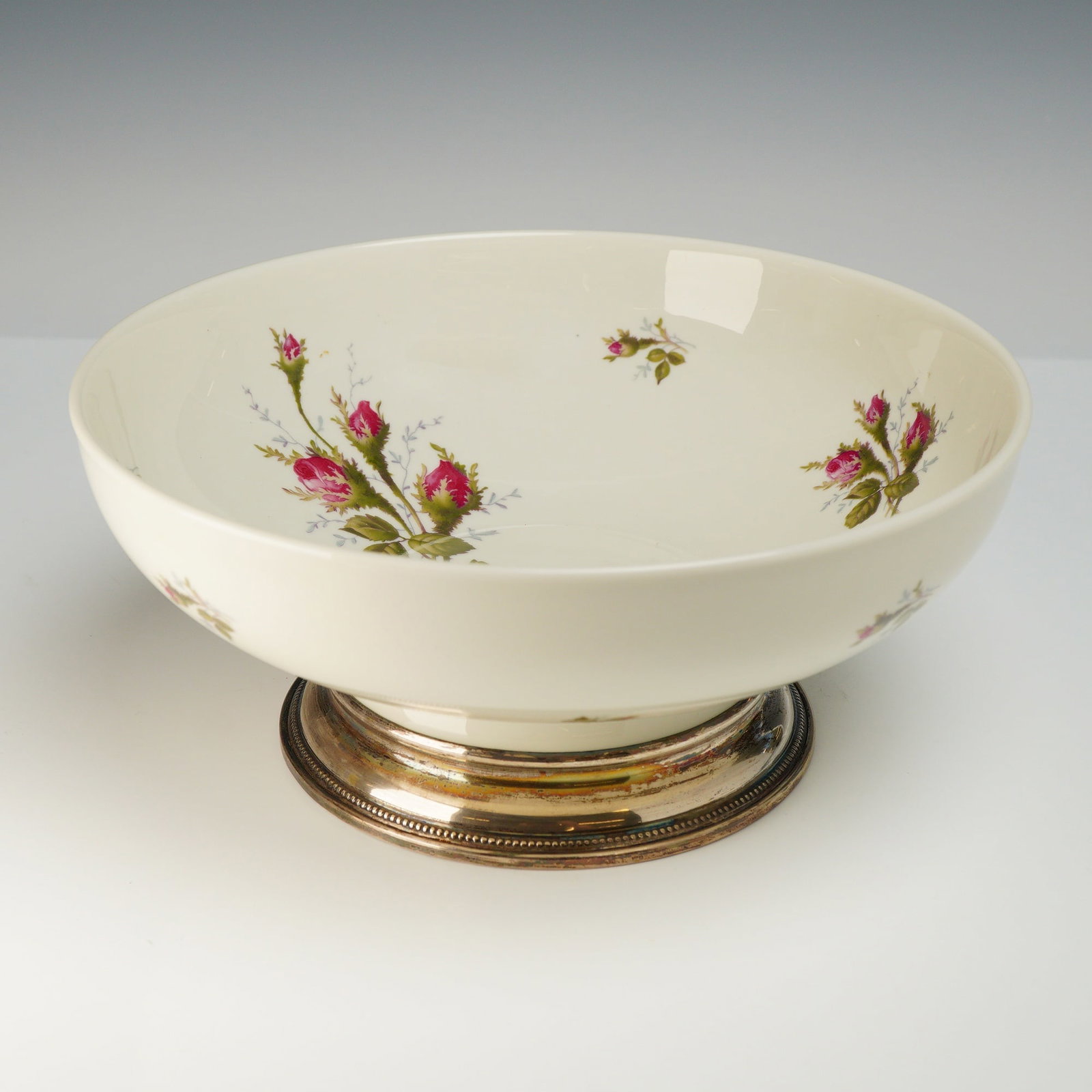 Rosenthal Aida Moss Rose Porcelain Footed Bowl with Sterling Silver Base: A Rosenthal porcelain footed bowl in the Moss Rose pattern piece is constructed from ivory-white glazed porcelain on the Aida blank, mounted to a flared sterling silver pedestal foot featuring a
