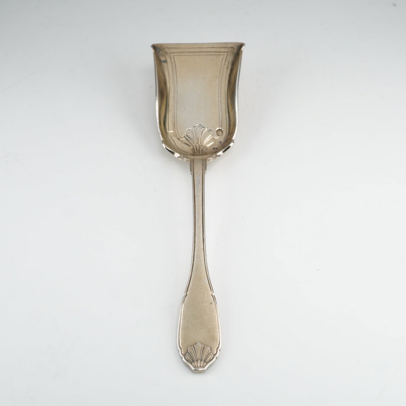 Cartier Sterling Silver Shell Motif Scoop Spoon Made in France: A sterling silver scoop spoon manufactured by Cartier in France. The item features a rectangular shovel-form blade with a flared leading edge and upturned, curved sides. The interior of the blade is d