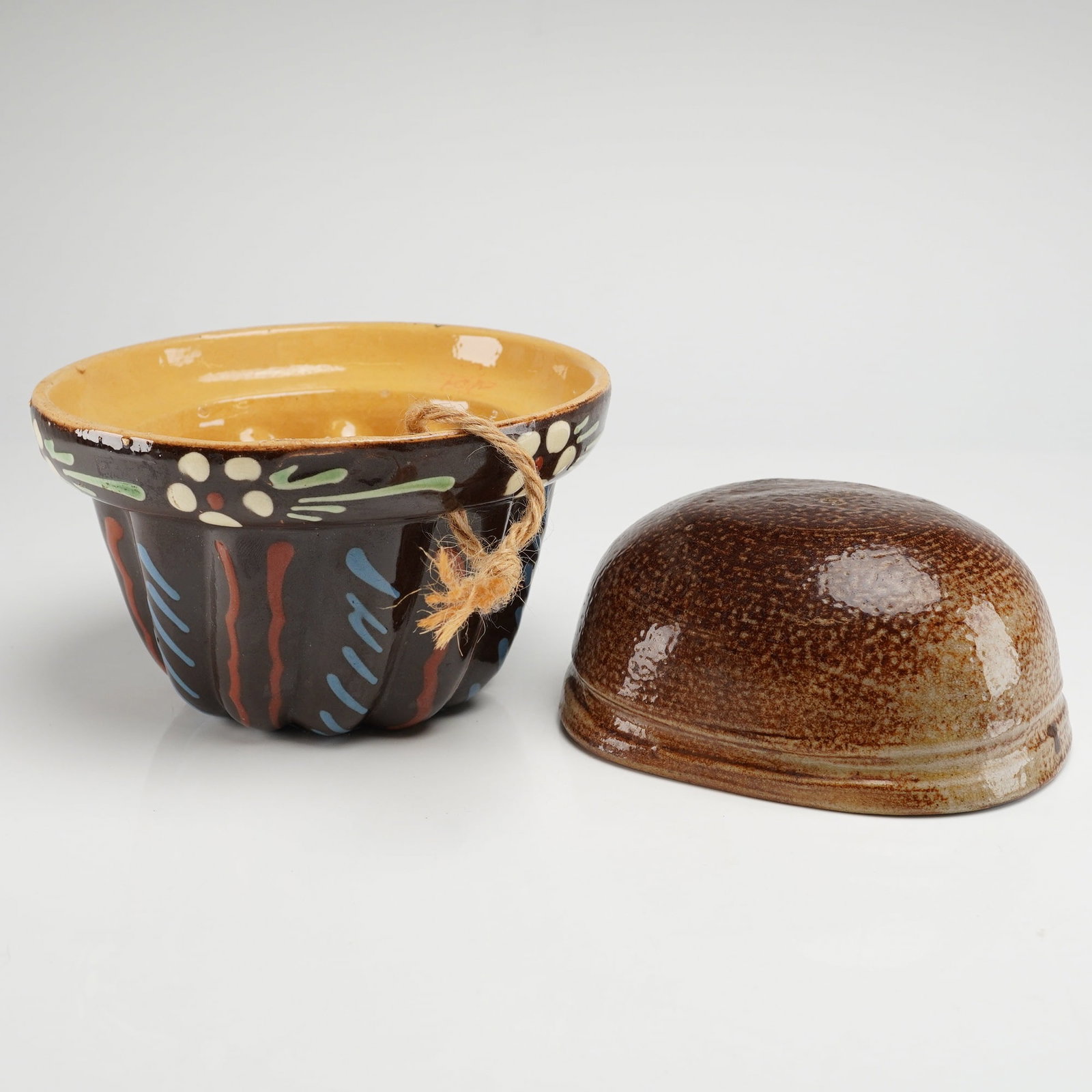 A Pair of Vintage Pottery Kugelhopf and Pudding Molds: A pair of glazed earthenware kitchen molds identified as vintage Alsace Pottery, likely originating from France. This 2pc lot includes a large Kugelhopf style mold and a smaller Jello or Pudding