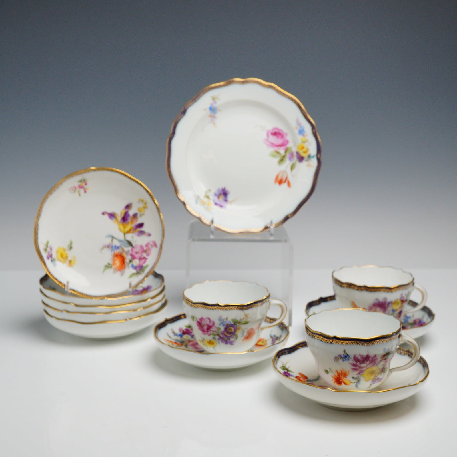 12pc Meissen Porcelain Tea Service: This 12 piece china tea service is manufactured from fine hard-paste porcelain by the Meissen factory. The set features hand-painted polychrome enamel floral motifs including roses, tulips, and pansie