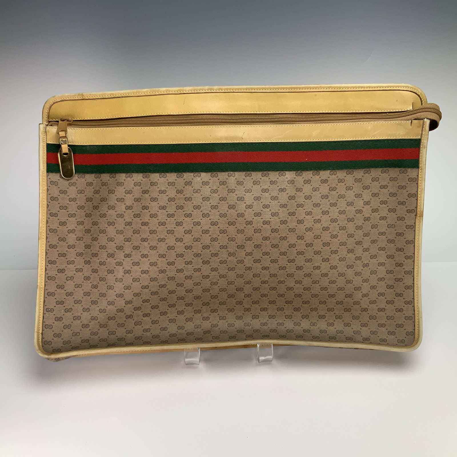 Gucci Briefcase Portfolio Bag with GG Monogram and Web Stripe: This vintage Gucci briefcase portfolio bag is crafted from the brand's signature micro GG monogram coated canvas in a beige and tan color palette. The exterior features a prominent green and red texti