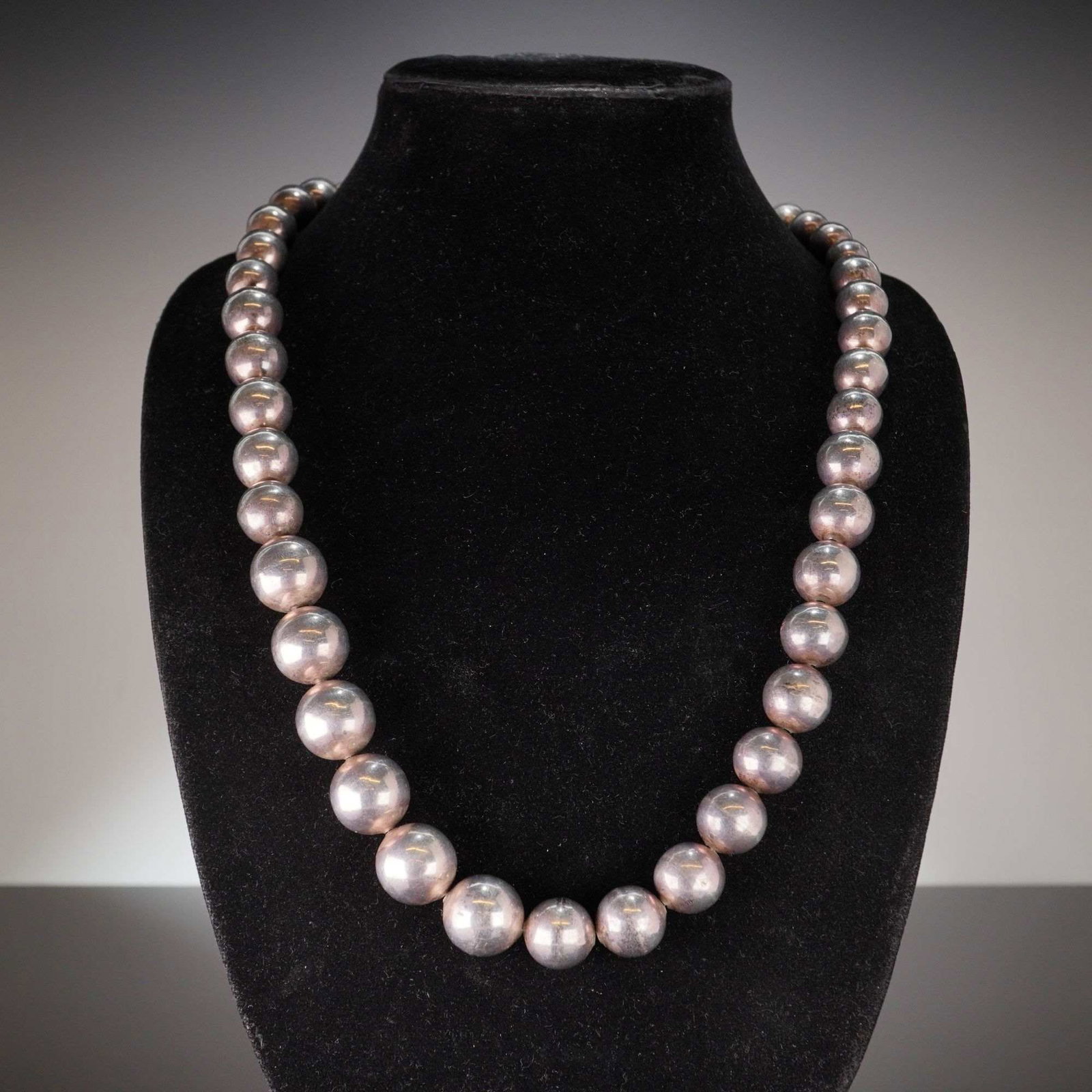 Taxco Mexico Sterling Silver Graduated Bead Ball Necklace: A graduated bead necklace of Mexican origin, produced by a Taxco silversmith. The piece is crafted from sterling silver and features a single strand of polished spherical beads that increase in size t