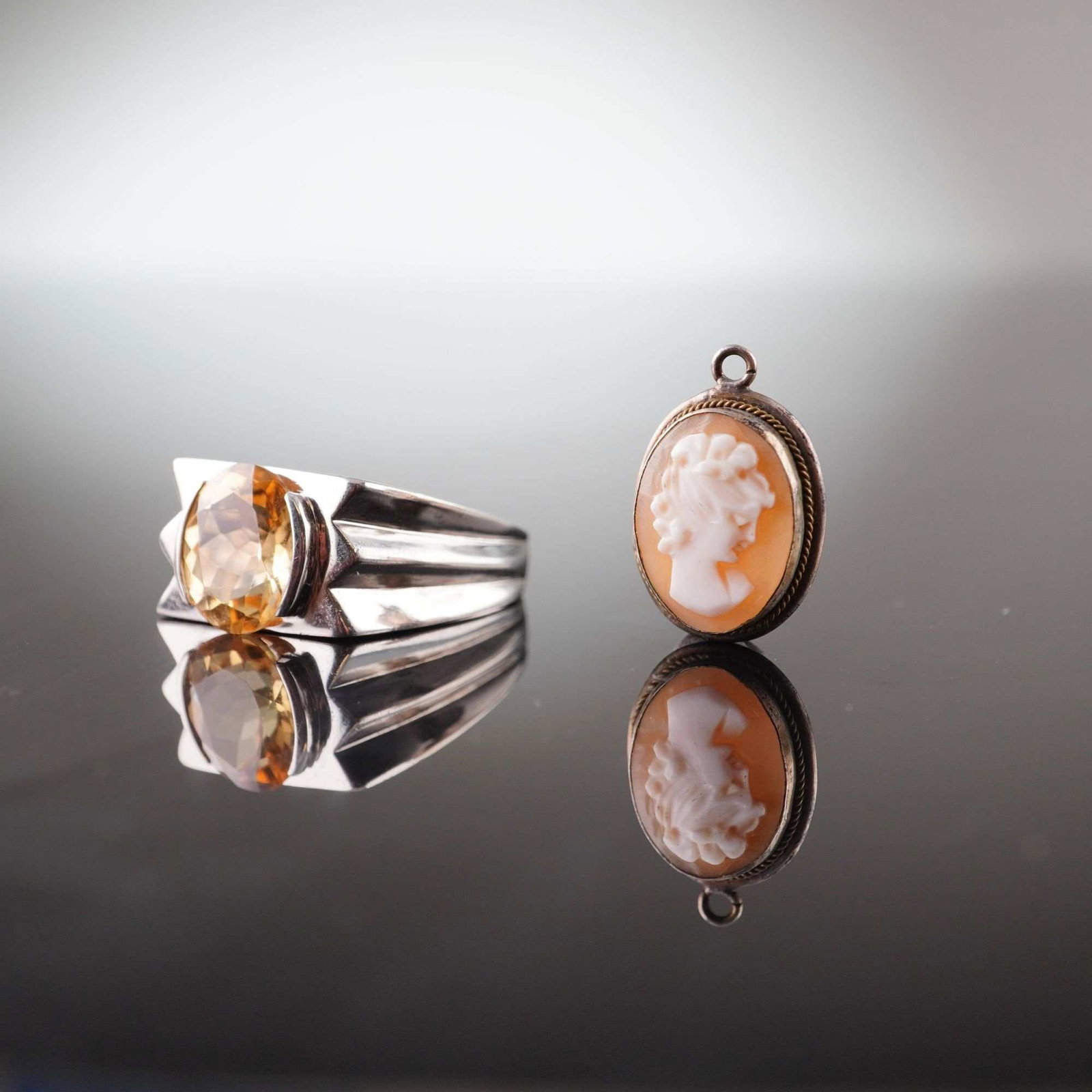 2pc Jewelry Pieces, Sterling Silver Citrine Gemstone Ring and Shell Cameo Pendant: This lot features two pieces of jewelry including a sterling silver ring and a carved shell cameo pendant. The first item is a contemporary sterling silver cocktail ring. The interior of the band is s