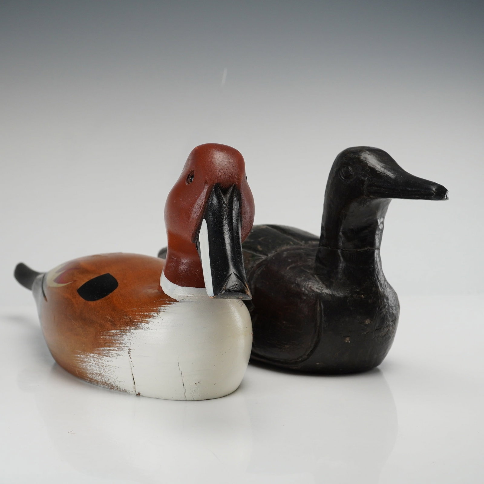 Set of Two Wooden Hand Painted Duck Decoys: This lot consists of a set of two wooden duck decoys. The first is a hand painted polychrome Northern Shoveler featuring a reddish-brown head with white highlights, a broad black bill, and inset glass