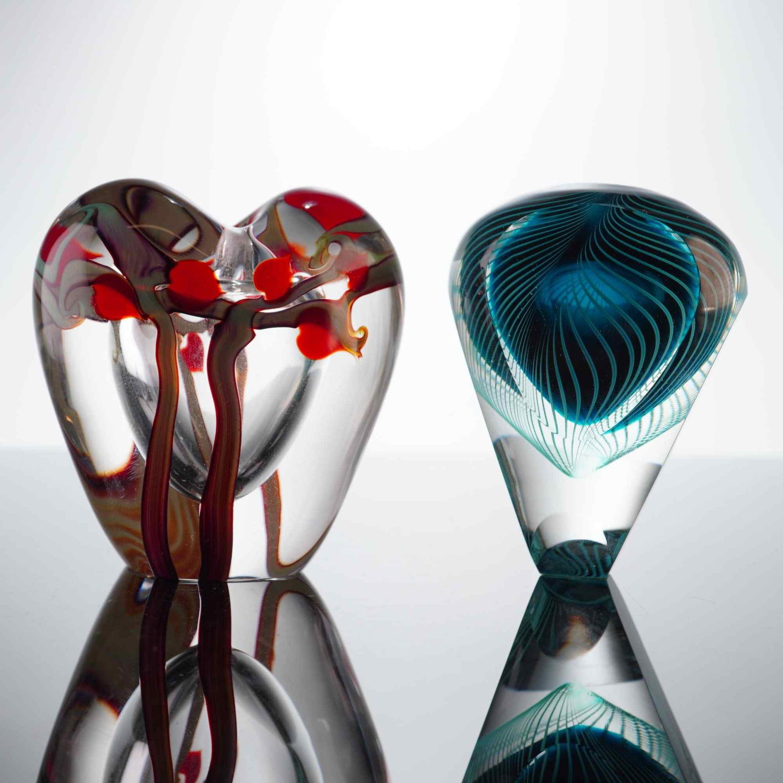 2pc Studio Art Glass Bottles, Zellique Heart Form & Signed Teardrop: The first piece is a thick-walled, heart-shaped bottle by Zellique Studio, dated 1993. It features a clear glass body enclosing organic, branch-like internal decoration in shades of red and burgundy w