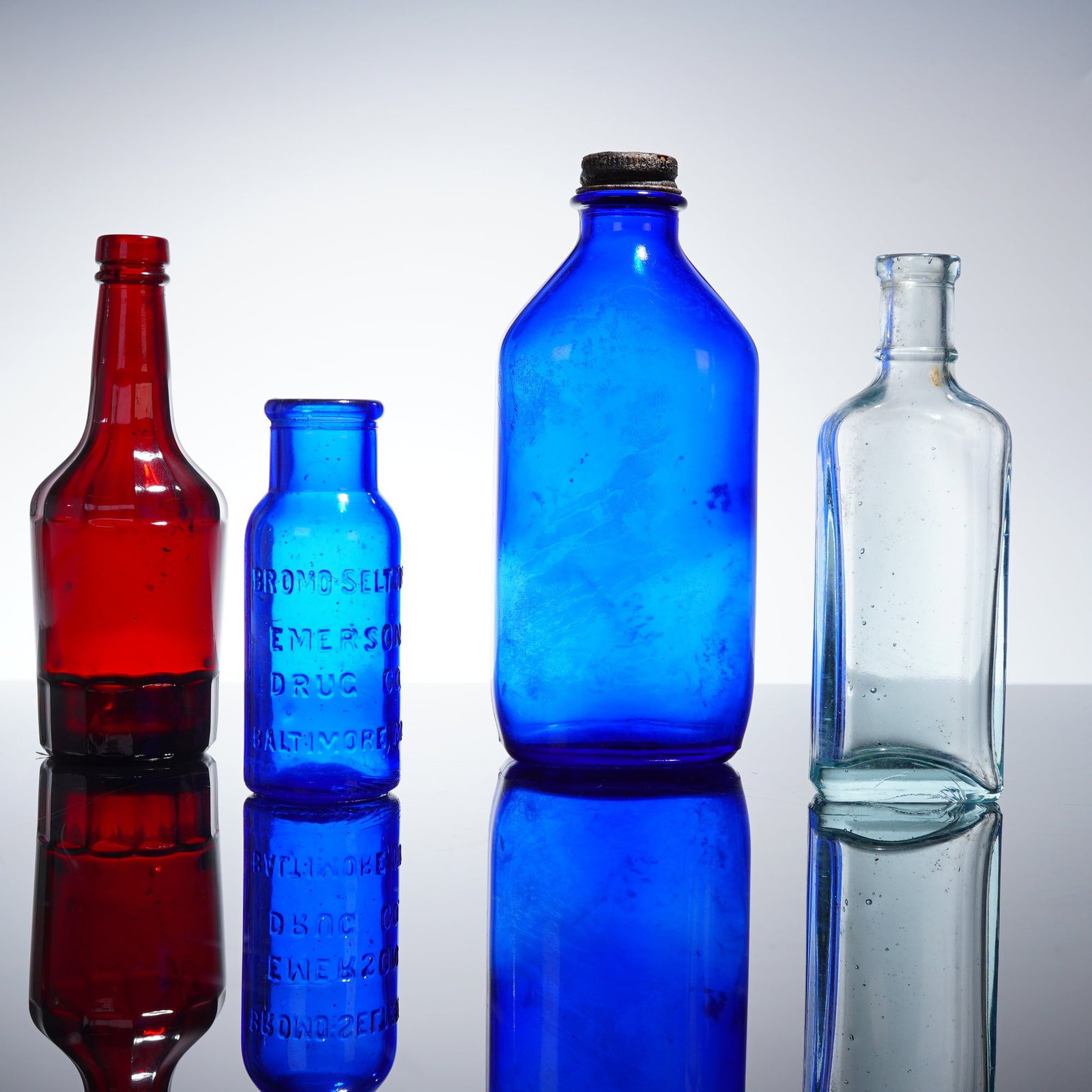 Collection of 4 Early American Pharmacy and Utility Glass Bottles: A collection of four early American pressed glass medicine and utility bottles, featuring examples from the Emerson Drug Co. Bromo-Seltzer and Chas. H. Phillips Chemical Co. Milk of Magnesia lines. Th