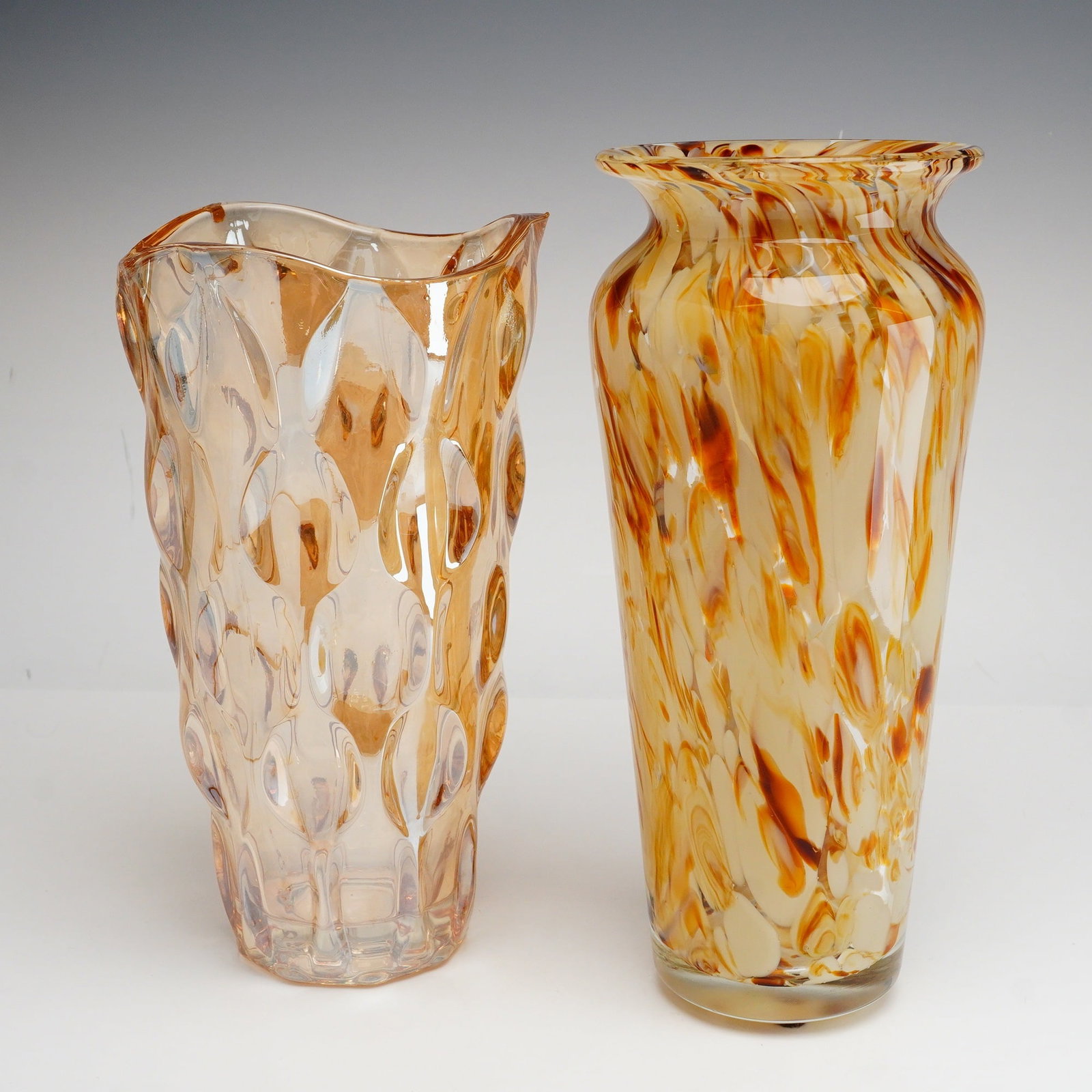 2pc Amber Textured and Marbled Spatter Style Art Glass Vases: The first item is a transparent honey-amber art glass vase with a bold, high-relief molded honeycomb or thumbprint pattern. The vessel features a wavy, asymmetrical rim and a ground, polished circular