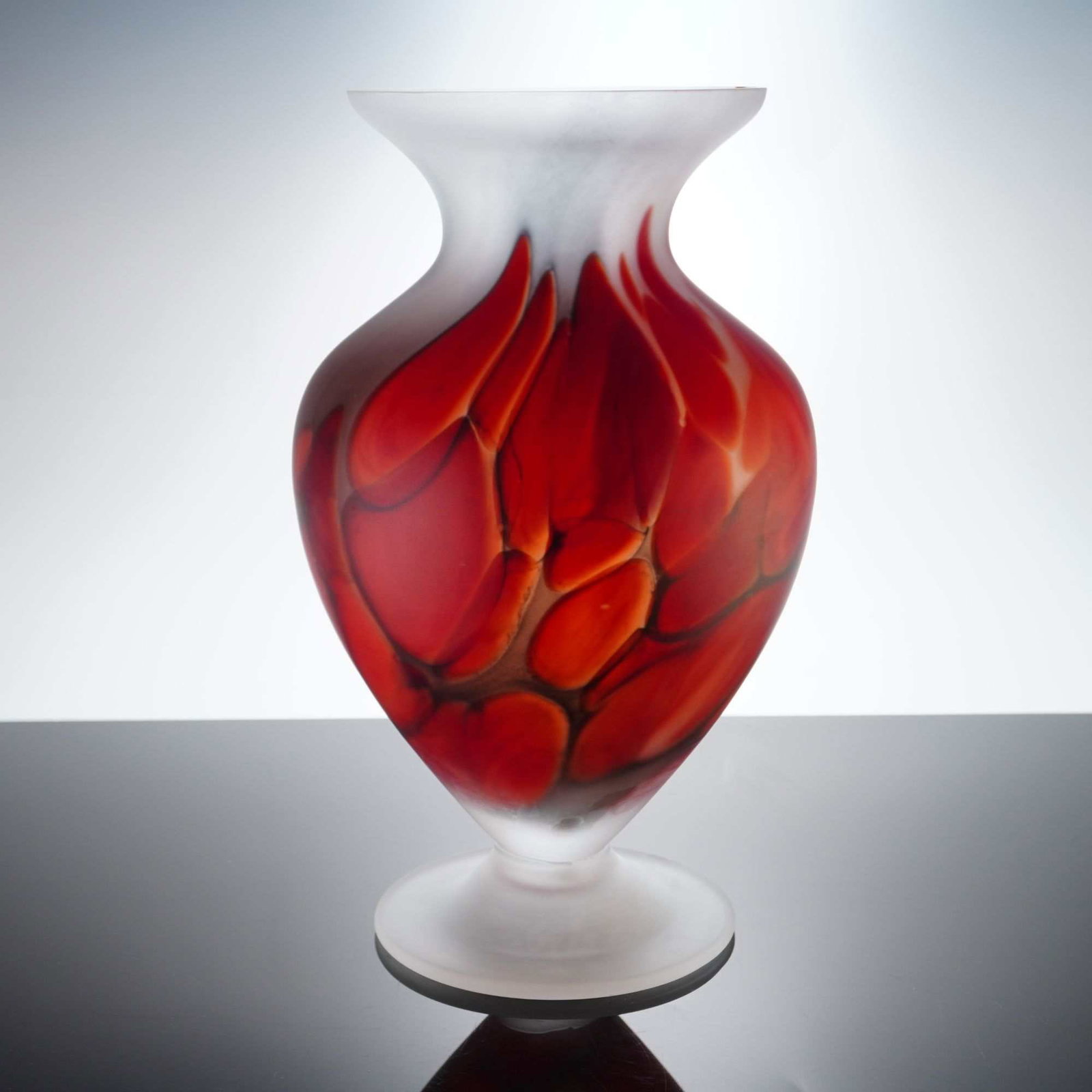 Attributed to Tarnowiec Polish Satin Red Bubble Design Art Glass Vase: The vessel features a wide flared rim and a circular pedestal foot. The central body is decorated with vibrant red and orange pulled, flame-like glass inclusions encased within a dark, web-like cell s