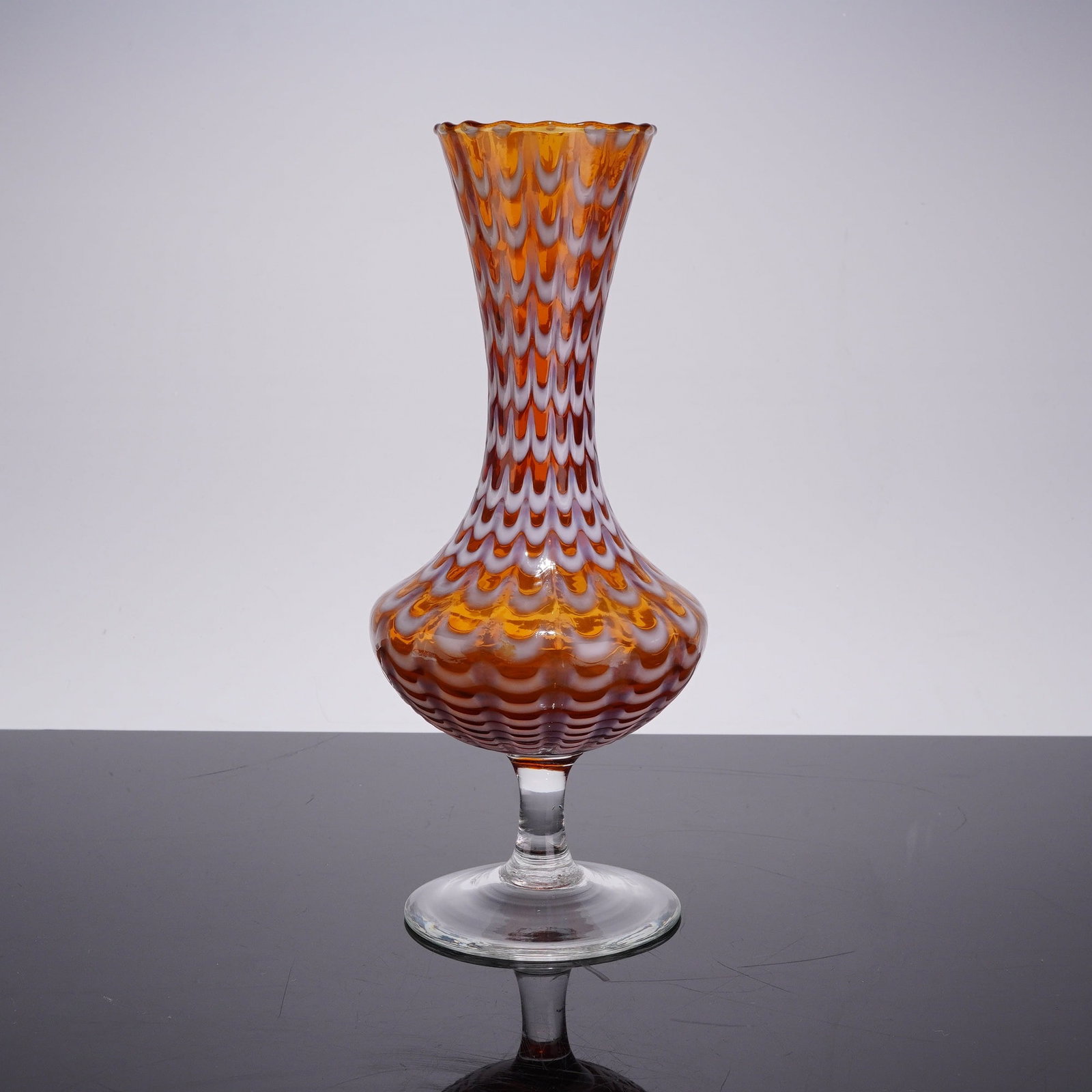 Italian Empoli Style Amber and White Drapery Pattern Art Glass Vase: This mid-century art glass vase is attributed to the glassmaking traditions of Empoli, Italy, based on its characteristic form and technique. The vessel is hand-blown from honey-amber transparent glas