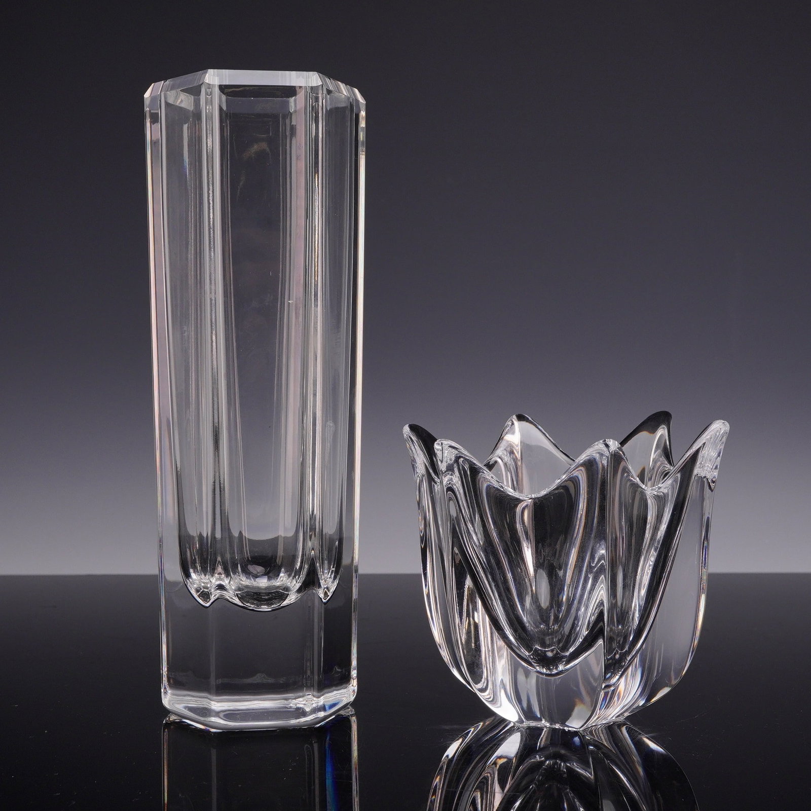 Two Swedish Art Glass Pieces including a Kosta Colonna Vase and an Orrefors Belle Tulip Bowl: This lot features two pieces of mid-century modern Swedish art glass from the Kosta and Orrefors glassworks. The first item is a tall, heavy faceted crystal vase by Kosta, designed by Bengt Edenfalk. 
