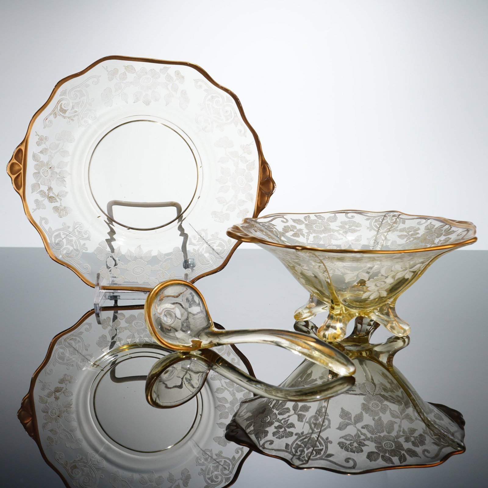 Three Cambridge Glass Apple Blossom Yellow Mayonnaise Tableware with Gold Trim: This three-piece glass set is manufactured by the Cambridge Glass Company and features the Apple Blossom pattern. The set is comprised of a tri-footed bowl, a two-handled underplate, and a coordinatin